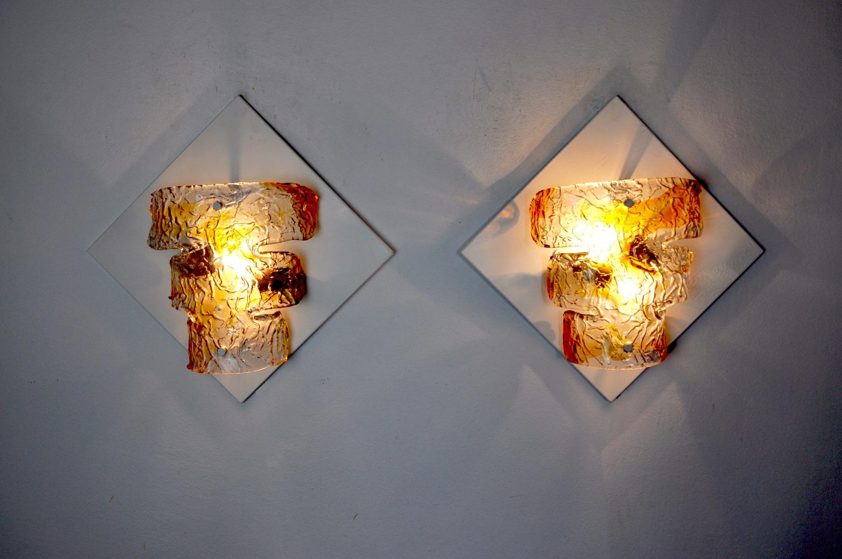 Very beautiful and large pair of murano mazzega wall lamps designed and produced in italy in the 1960s.
Composed of an orange murano glass crystal and a white metal structure.

Unique object that will illuminate perfectly and bring a real design