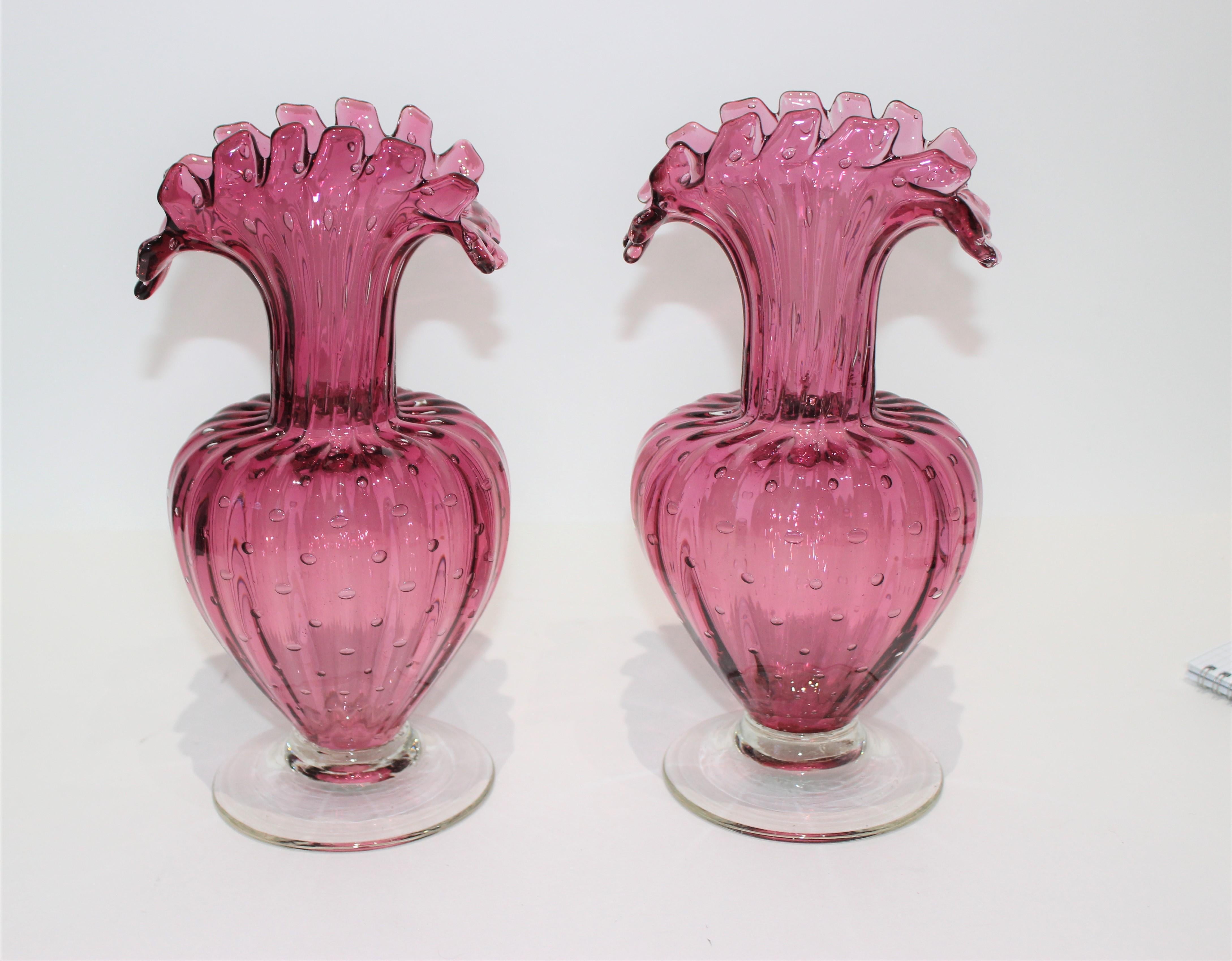 Murano ribbed bucillante controlled bubble raspberry pink vases with original Venice label, a pair. Acquired from a Palm Beach estate.

These are not exactly the same, being hand blown by the Murano artisans, but close enough for us to call them a