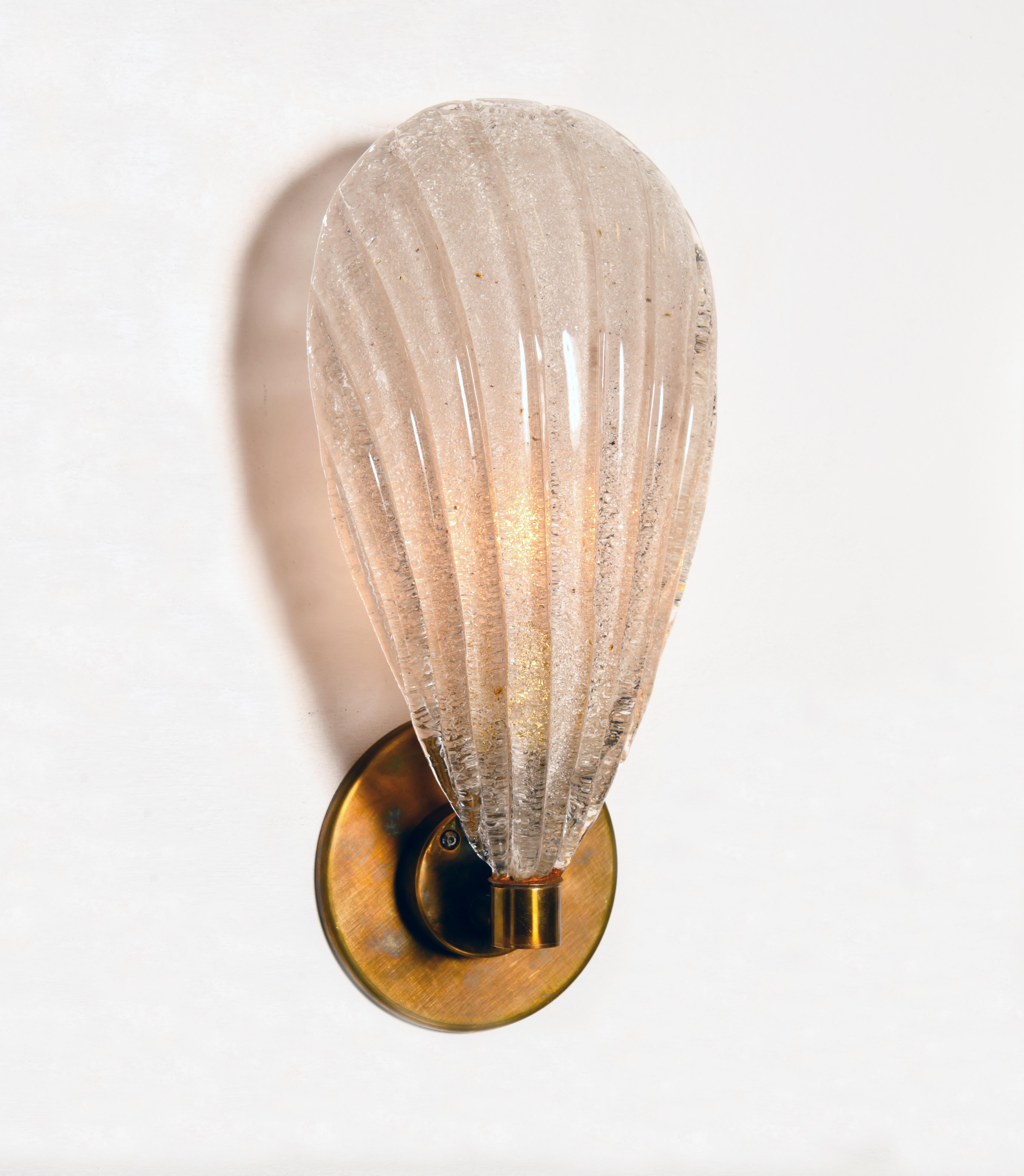 Deliziose applique Piastra in vetro fuso nel classico Cristale D'Oro - Trasparente con Oro 24K - con piastra posteriore rotonda a gradini e armatura in solido ottone antico.

Lo Studio Thomas Cooper rappresenta una collaborazione multistrato e