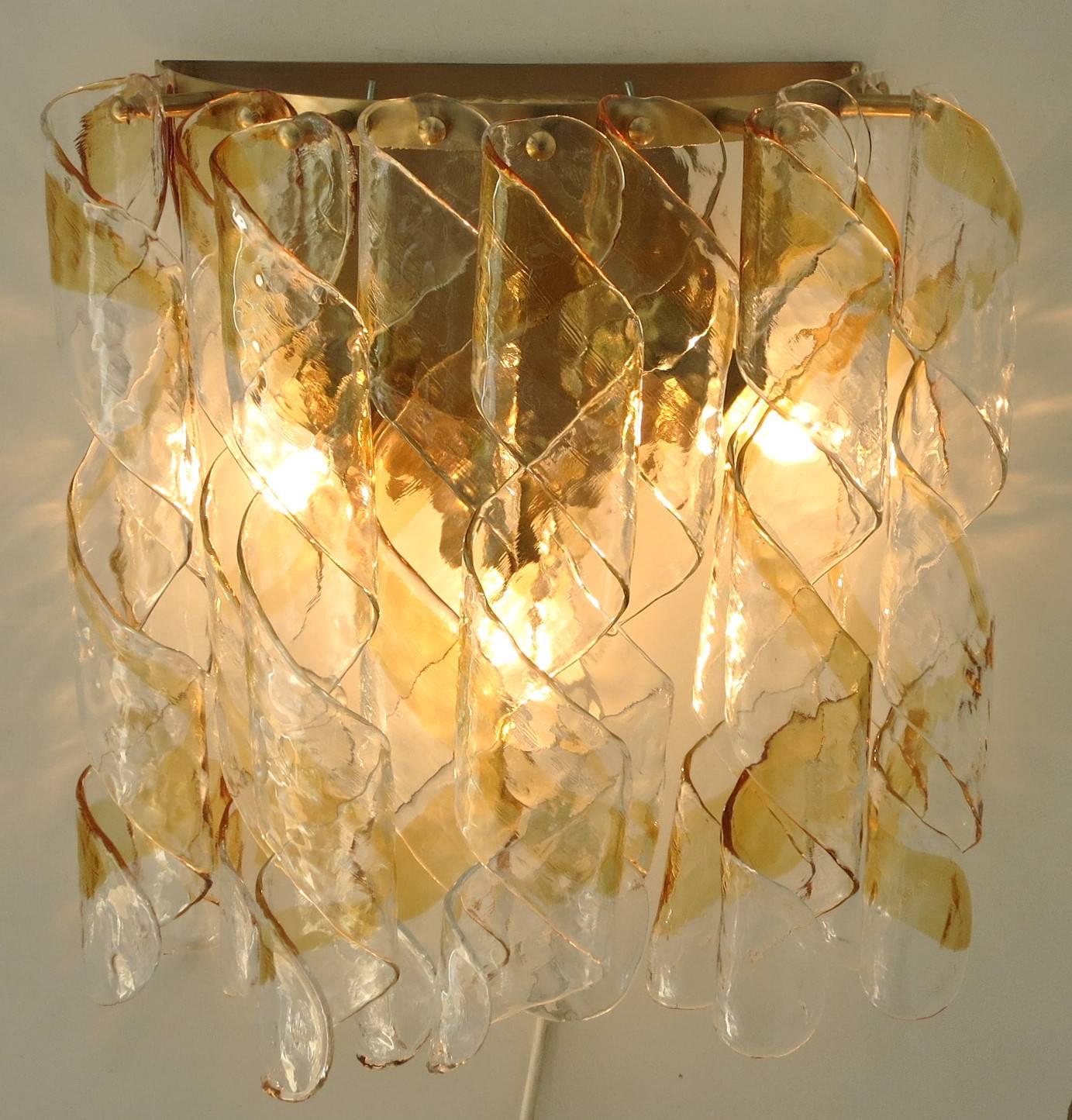 Original vintage pair of Italian wall lights with clear and amber Murano glass spiral ribbons that form a diffused effect, mounted on brass frames / Designed by Mazzega, circa 1960’s / Made in Italy
3 lights / E26 or E27 type / max 40W each
Height: