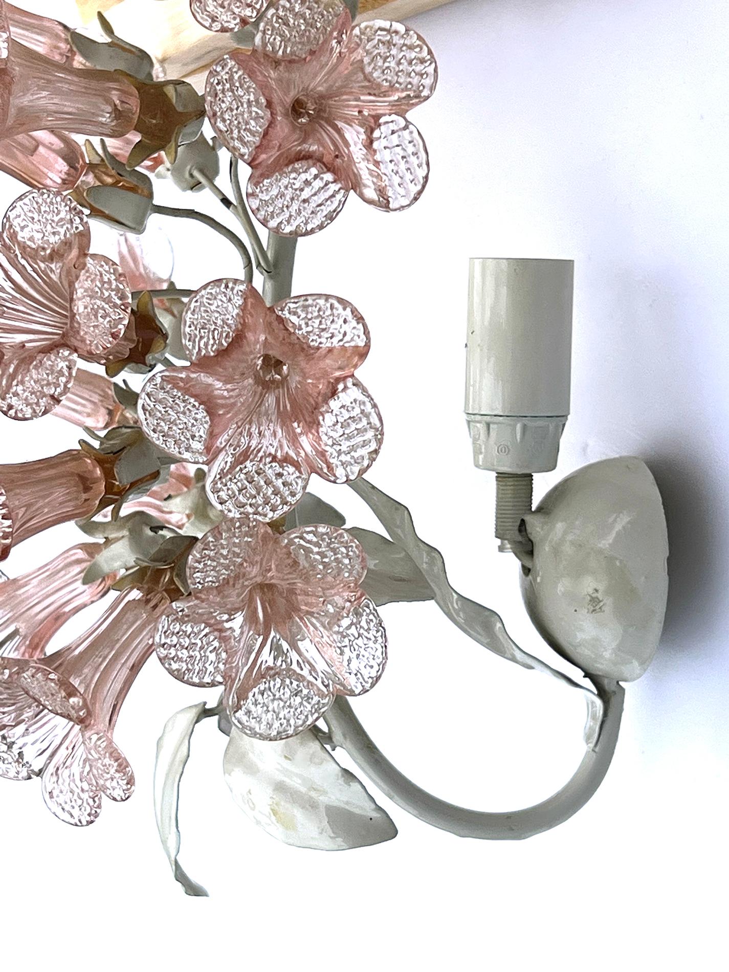 Each white enameled wall sconce emanating several rose-colored bell flowers above a cluster of white enameled leaves; each fitted with a single chandelier socket