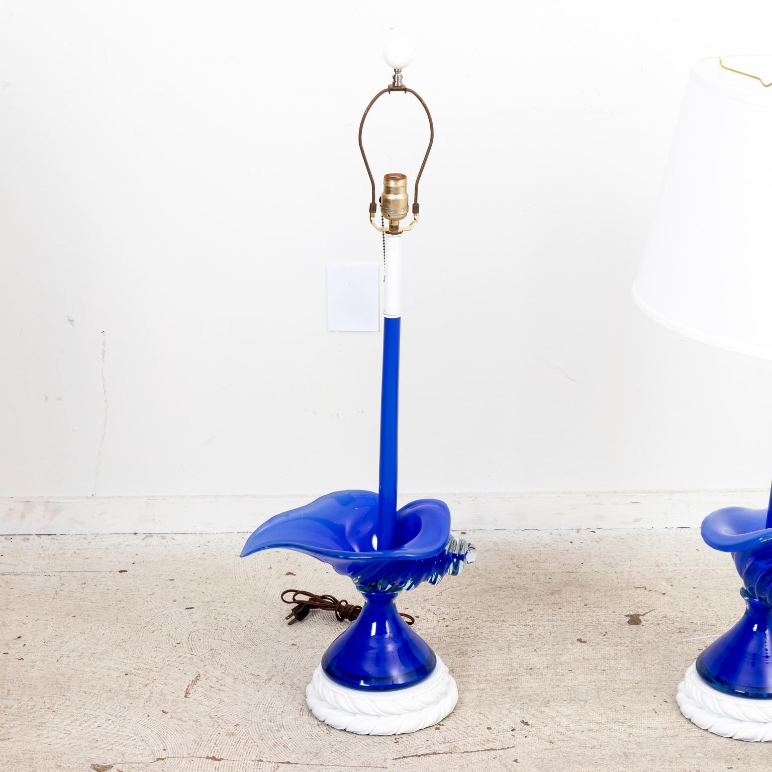 Pair of Mid-Century Modern style blue Murano glass table lamps in the shape of large Conch shells with contrasting round white color base with foliage trim. Shades not includes. Please note of wear consistent with age.