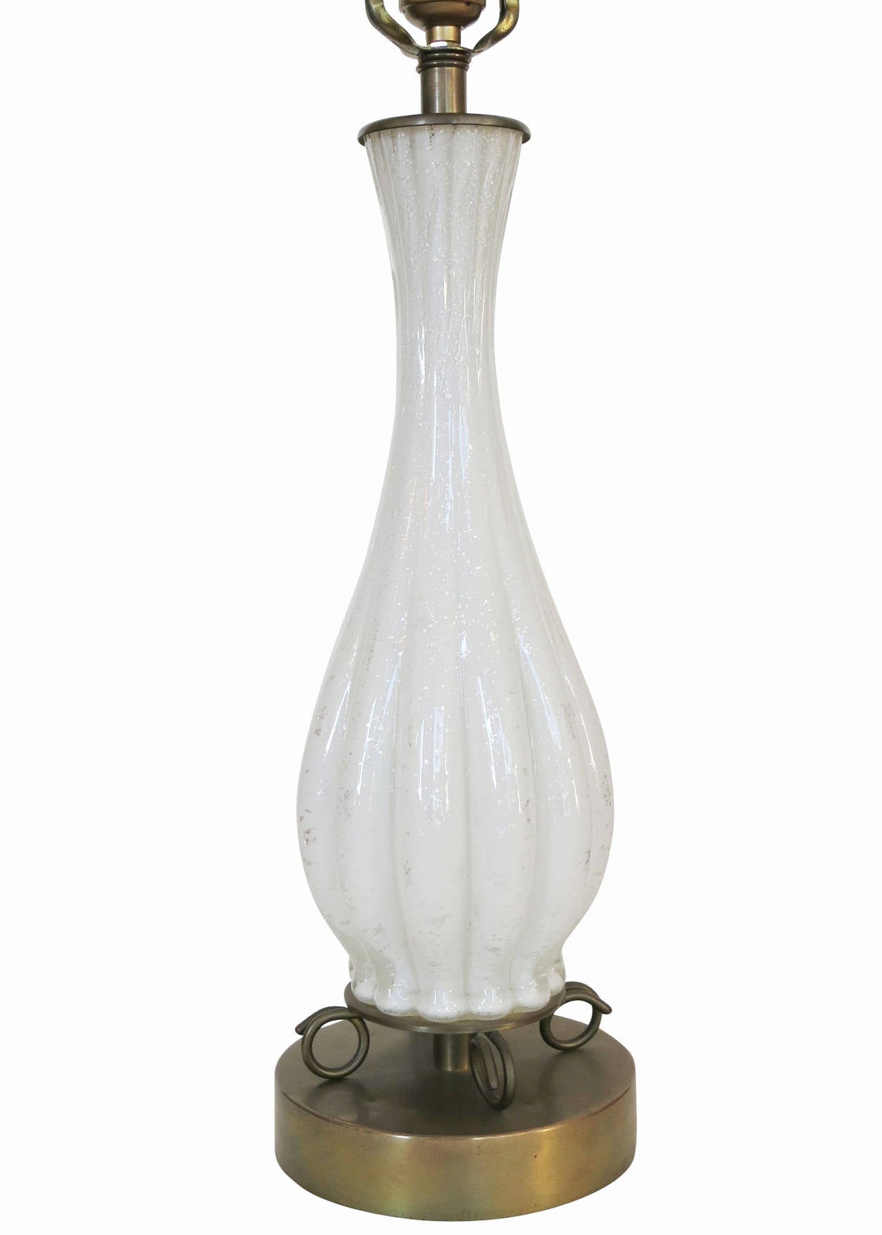 Pair of large elegant hand blown glass white Murano table lamps. The long stretched hour glass center piece is fixed to a decorative Midcentury brass base and finished with a brass top fitter.

The lamps feature a unique silver flake worked into