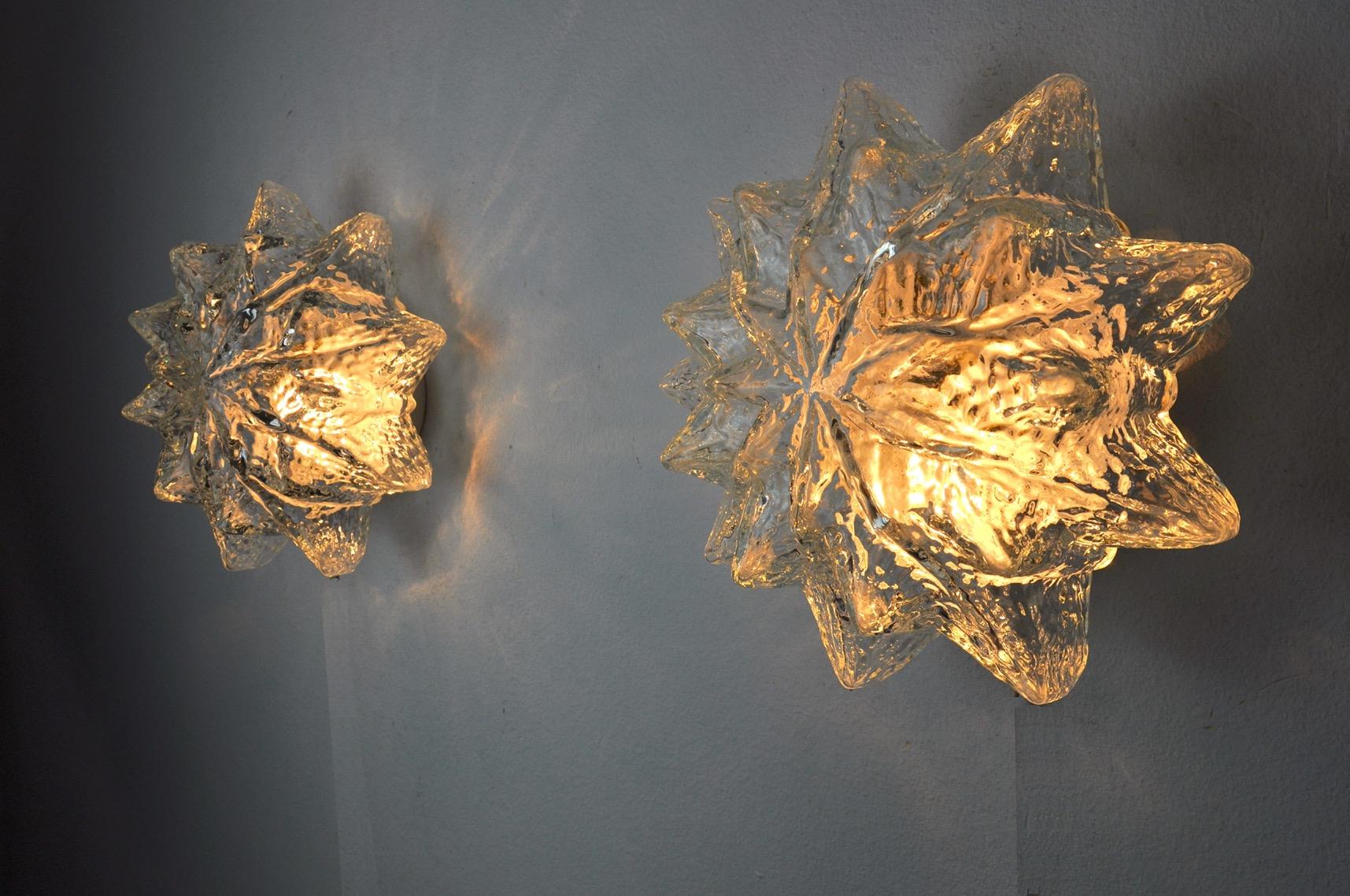 Very beautiful and rare pair of Murano wall lamps designated and produced in Italy in the 1970s.
Composed of two star shaped Murano glass crystal globes and a white metal structure.
Unique object that will illuminate wonderfully and bring a real