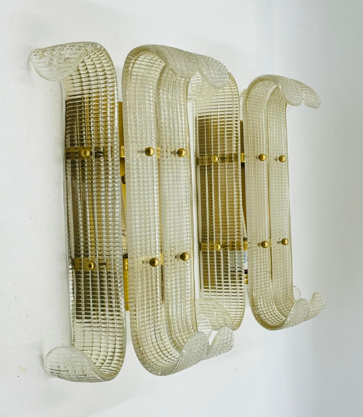 Paire d'appliques murales en laiton de style Murano.

Les appliques sont composées de pièces de verre semblables à des feuilles, fixées à un cadre en laiton et maintenues par des boules en laiton.

Les pièces ne sont pas marquées.

Dimensions :