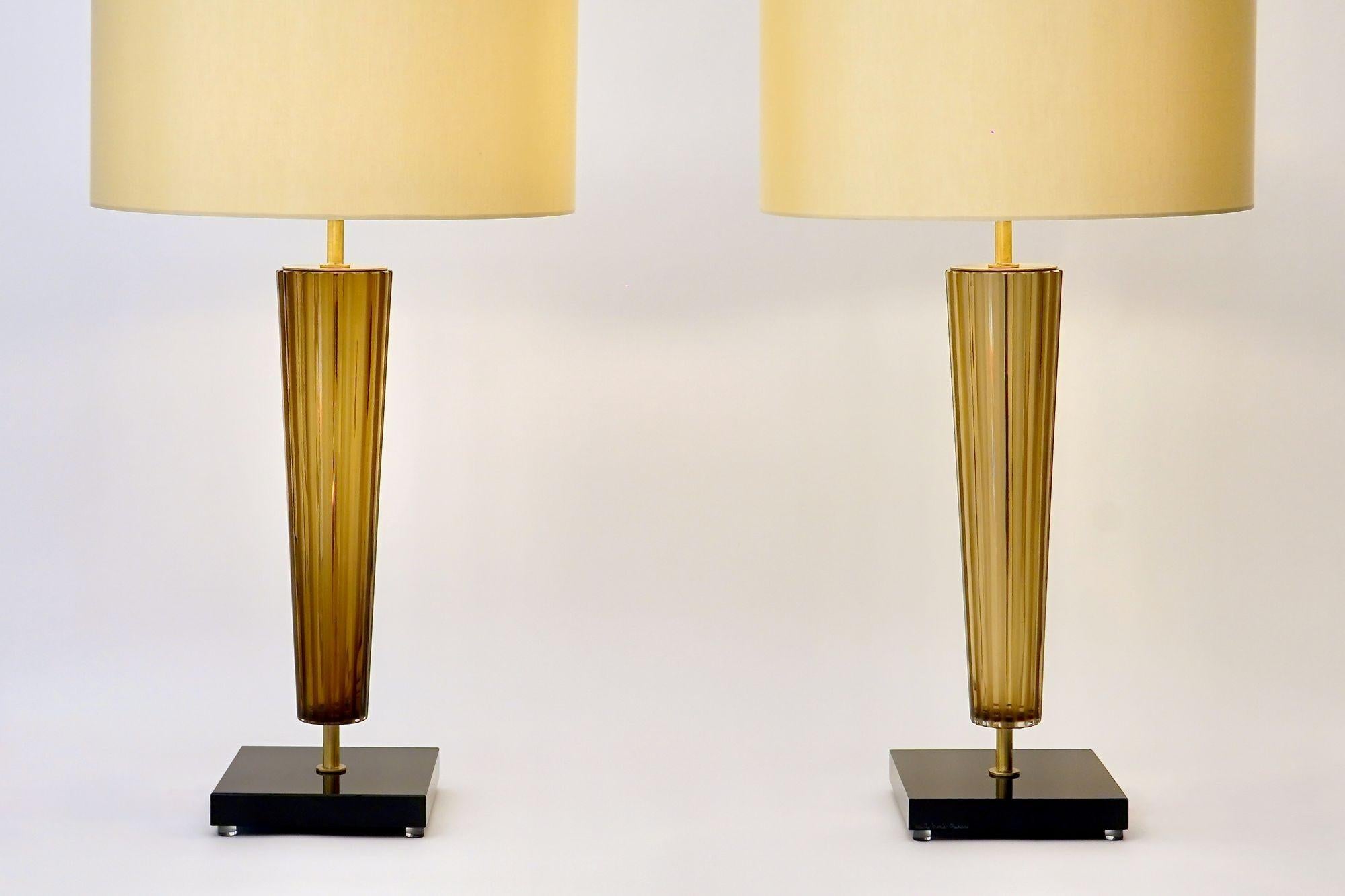 Pair of Amber Reverse Cone Murano Table Lamps by Alberto Donà — Maestro Collection

A pair of table lamps crafted entirely in Murano at the Alberto Donà furnace. Each lamp features a substantial reverse-cone body in light amber glass; the ribbed