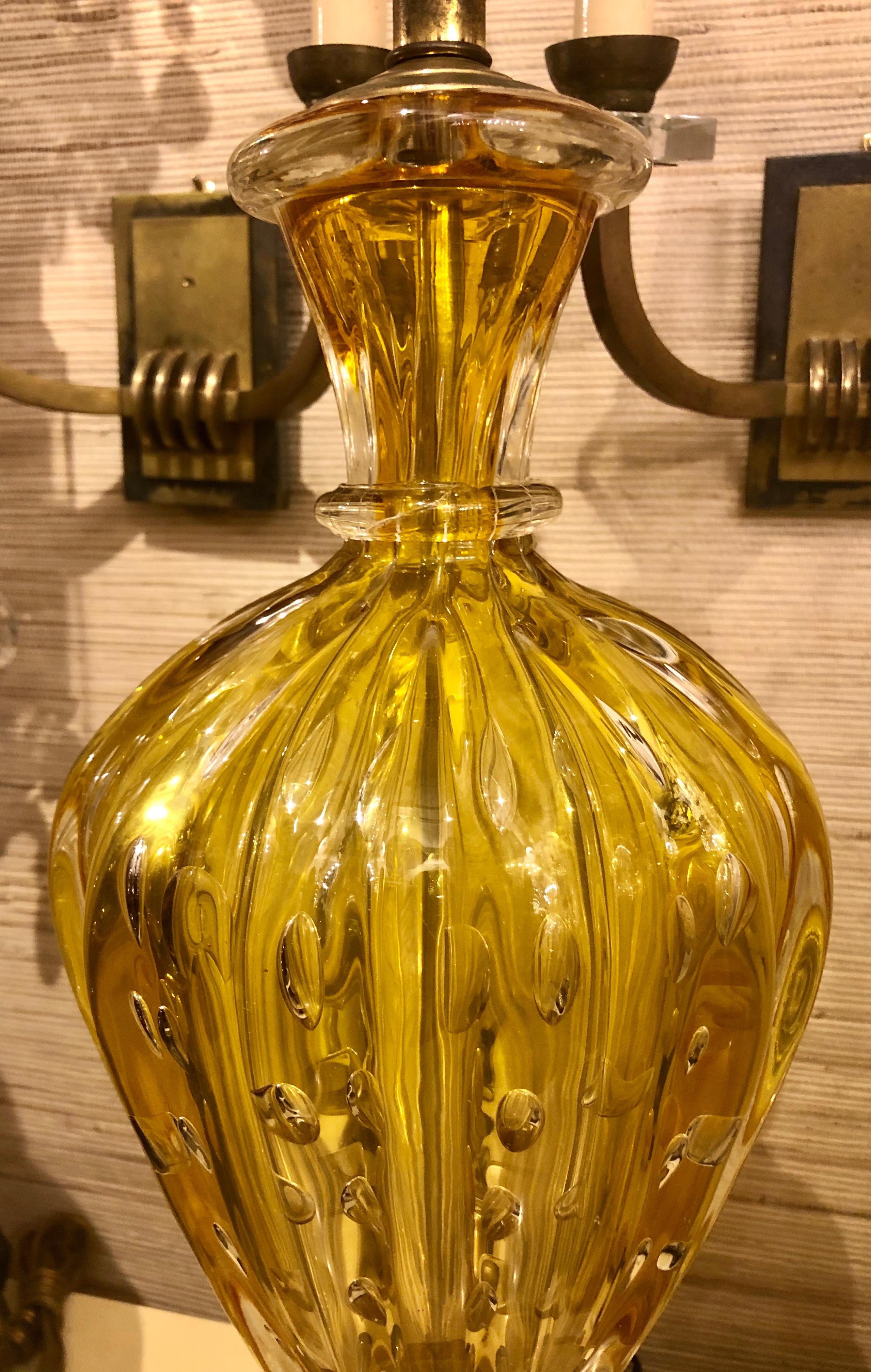 A pair of circa 1920's Italian Murano glass table lamps in yellow and gold tones, with controlled bubbles in body.

Measurements
Height of body: 19