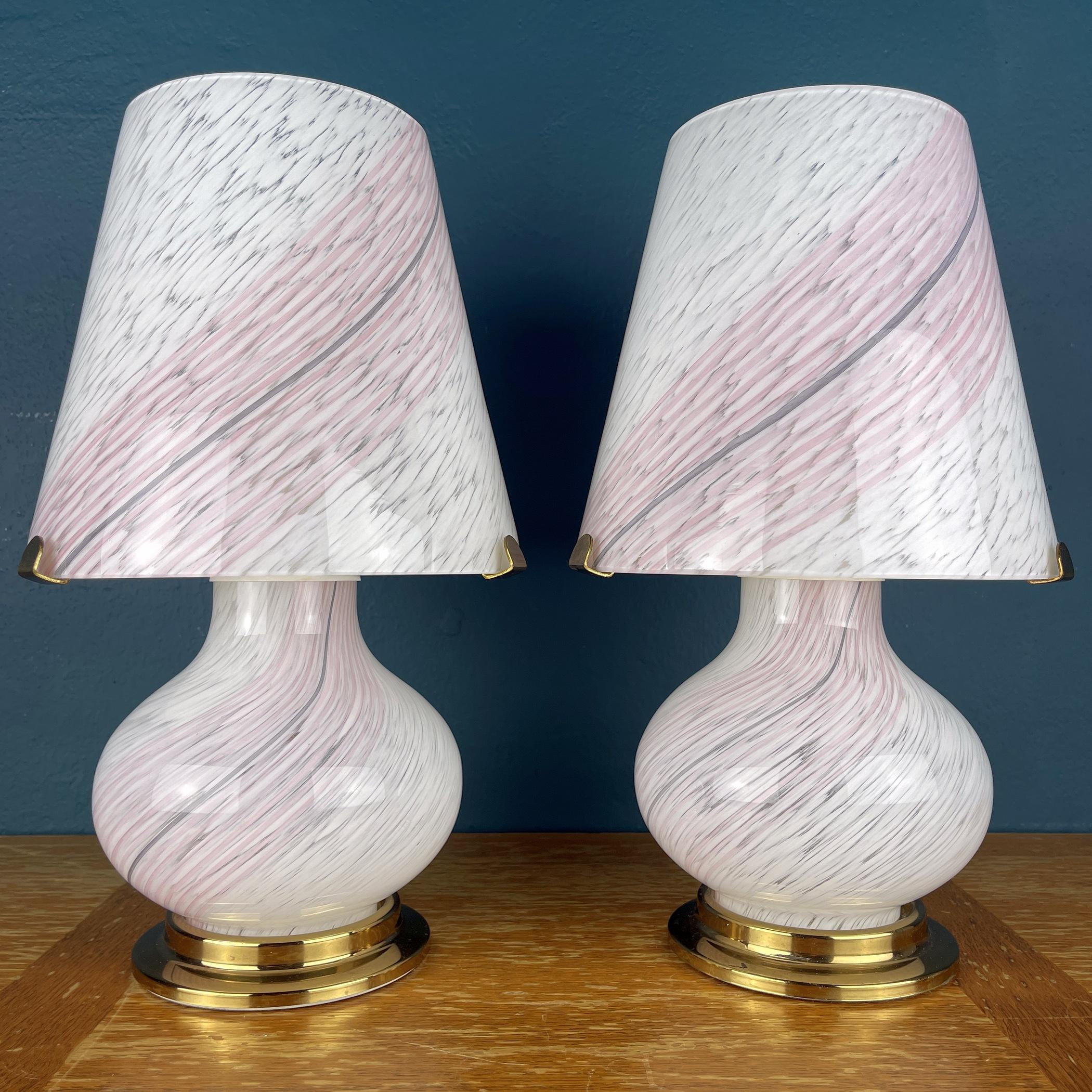 The pair of beautiful Murano mushroom lamps made in Italy in the 1970s. The beauty of the classic swirl glass makes these lamps a pleasure to look at. The elegantly shaped base carries a sturdy metal bracket to support the large conical lampshade.