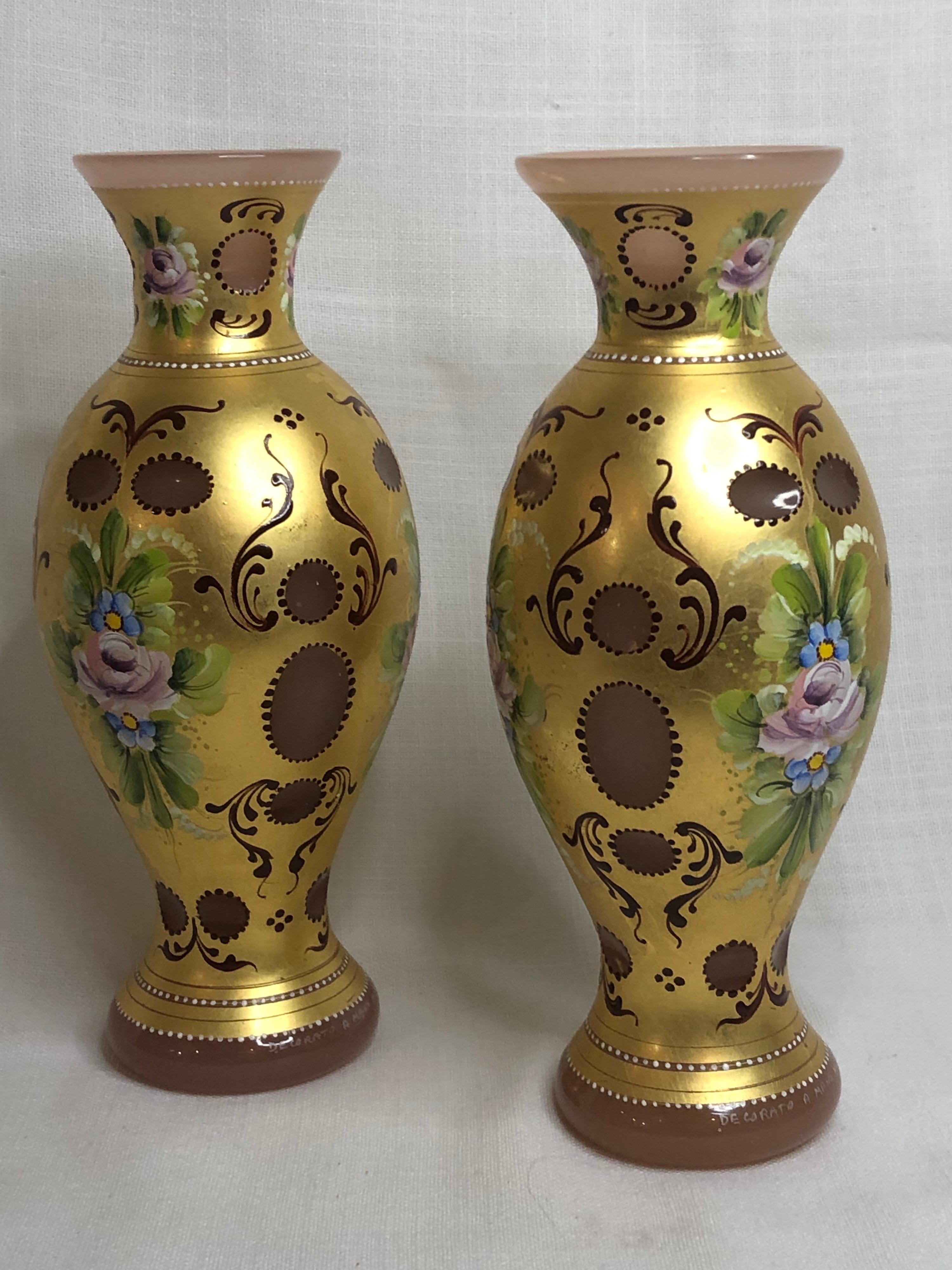 Je vous propose cette magnifique paire de vases en verre de Murano. Ces vases sont décorés d'or 24 carats et de roses roses peintes à la main sur un fond de verre rose taillé. Ils feraient des vases exquis pour les compositions florales que vous