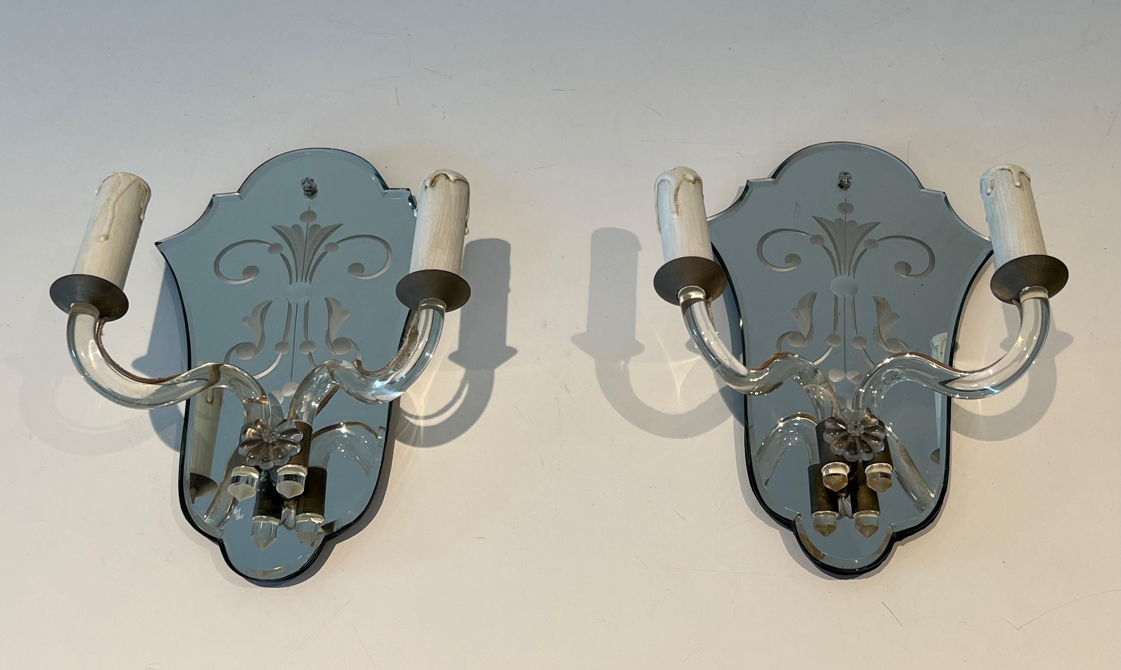 Questa bella coppia di lampade da parete è realizzata in specchio inciso, cristallo e metallo argentato. Si tratta di un'opera italiana realizzata a Murano. Circa 1940