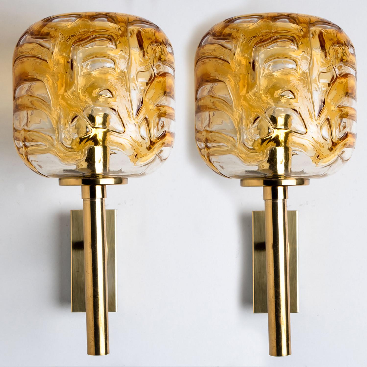 Pair of  Doria wall lights (in collaboration with Murano) in the style of Venini, manufactured, circa 1960.
High-end thick Murano crystal glass shade made out of overlay yellow glass, applied in irregular swirls. Mind blowing lighting effect when