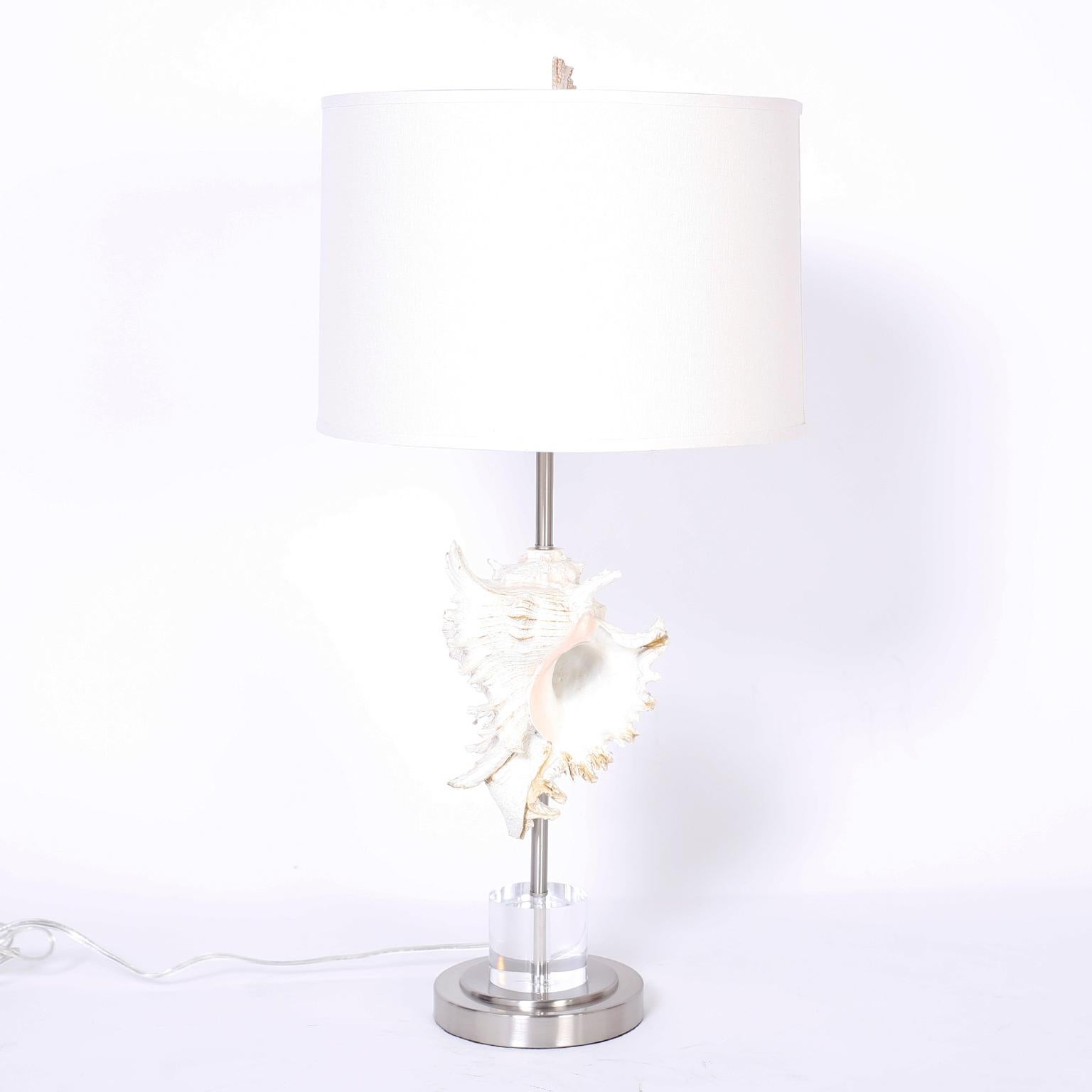 Pair of table lamps with composite murex shell mounted on metal rods over a Lucite stand on a metal base.