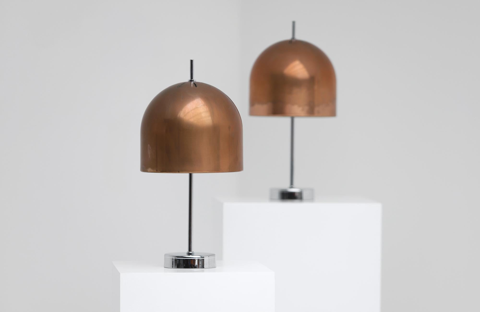 A pair of 1970s table lamps featuring mushroom-shaped shades. The lamps have a chrome steel base,  the shades are made from warm-hued copper. Over the years, both lamps have developed a beautiful patina. When lit, they have a soft light, perfect for