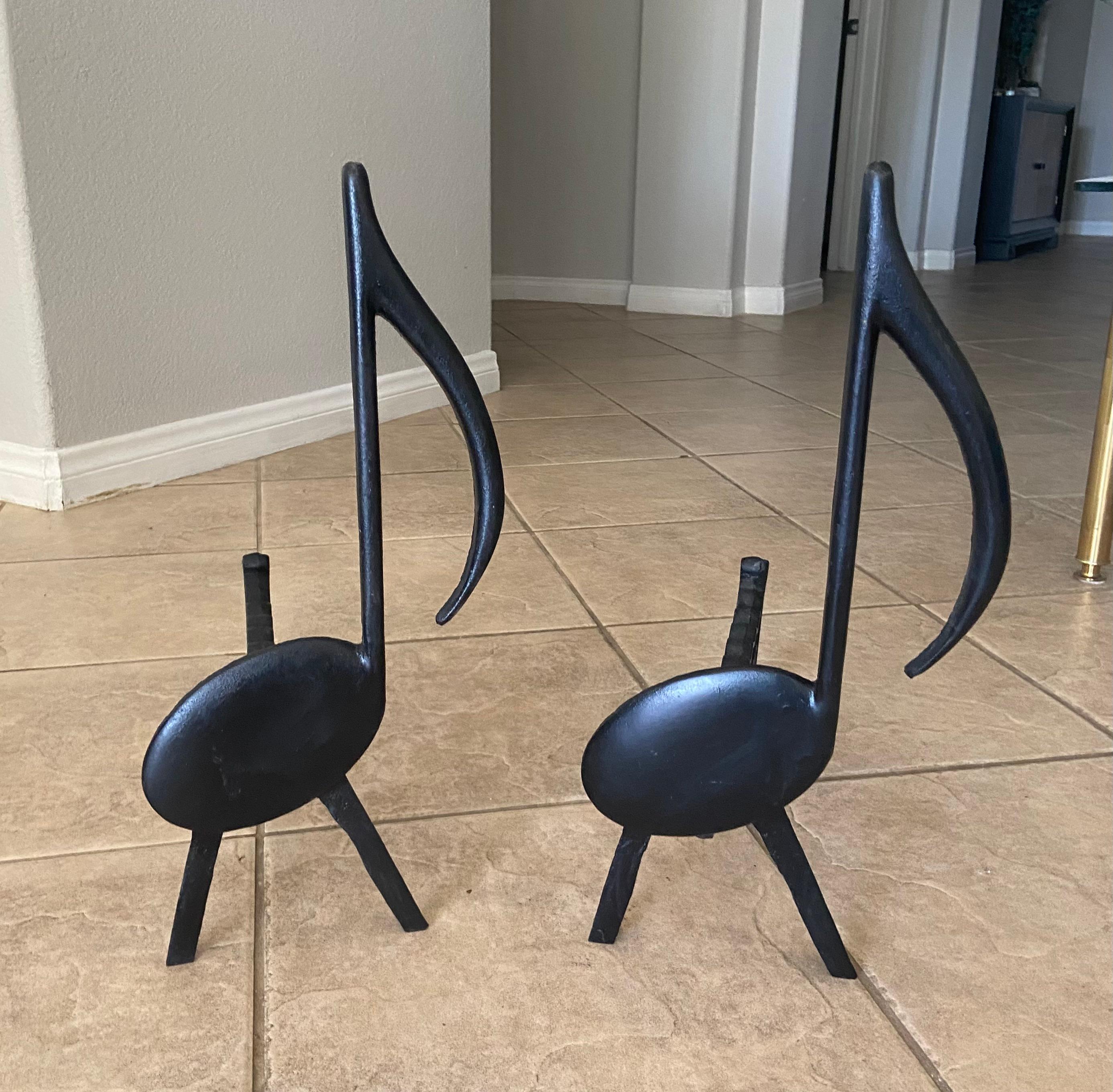 Pair of mid century black cast iron music note motif fireplace andirons by Tennessee Chrome Plate of Nashville.