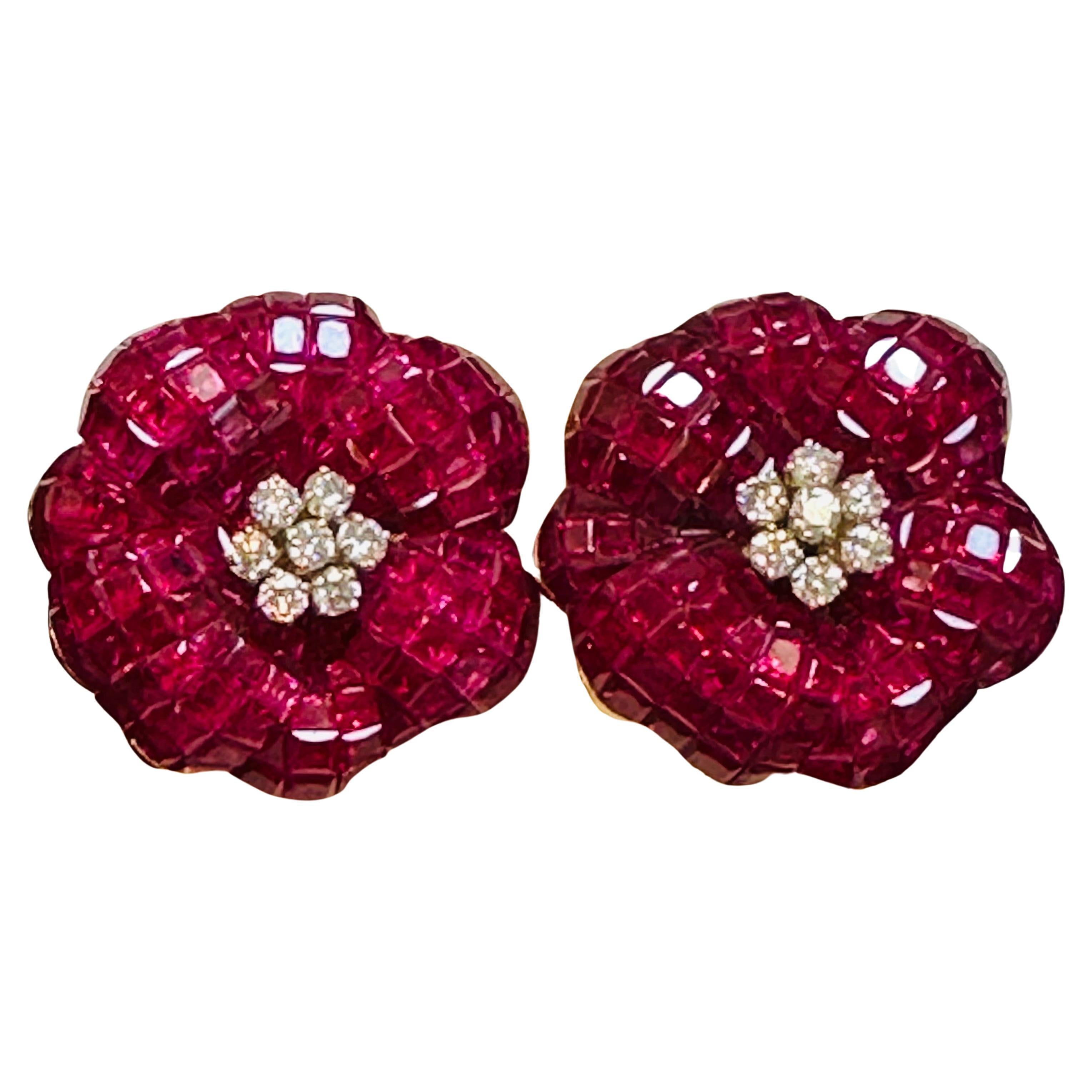 These stunning cocktail earrings feature an invisible or mystery set of princess cut Burma ruby and diamond flowers. set in 18 karat yellow gold. The princess-cut rubies are set in a beautiful flower frame, creating an intricate and elegant design
