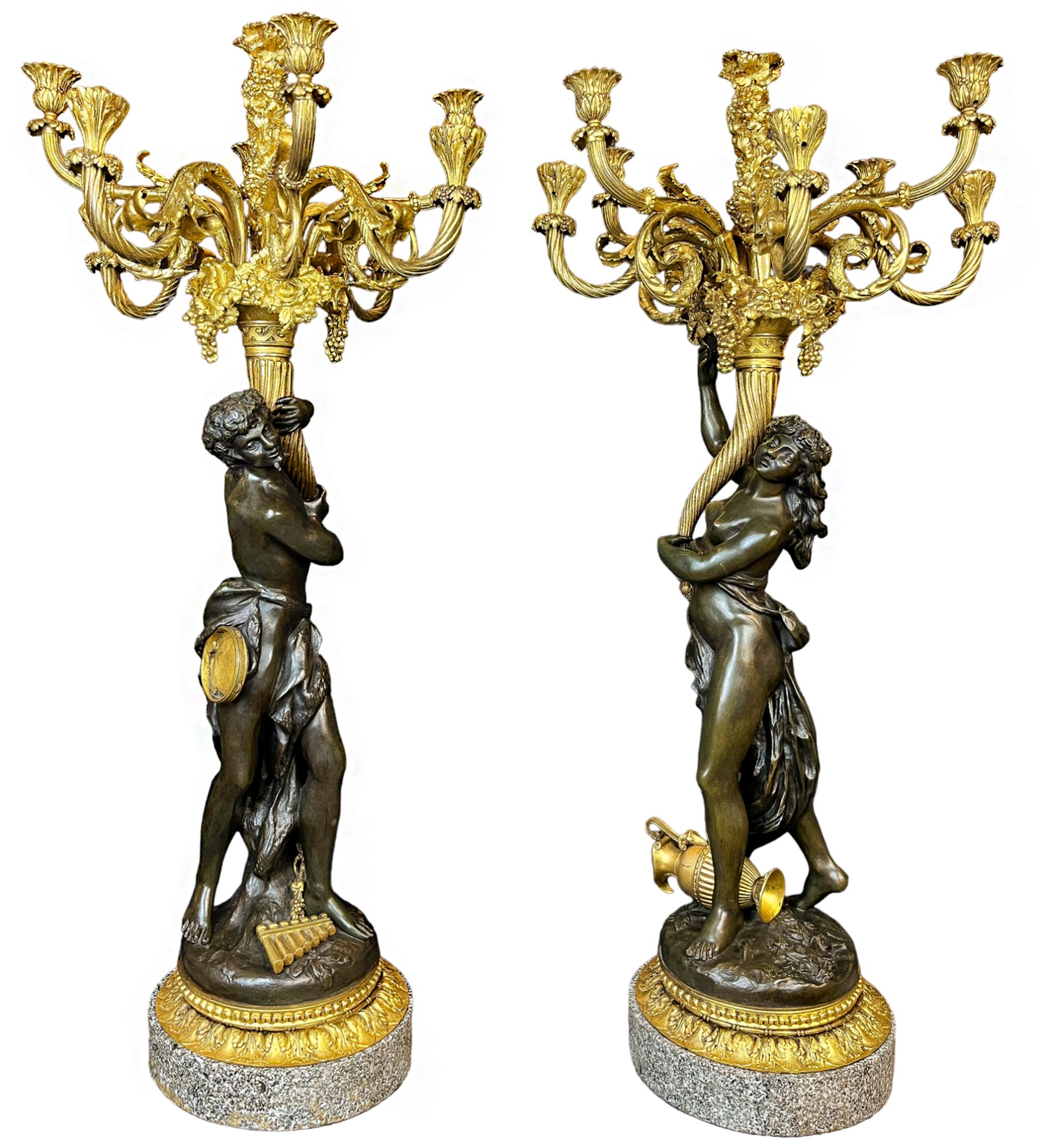 Coppia di candelabri alti a nove luci in bronzo figurato. Un satiro maschio e una baccante femmina in bronzo patinato verde scuro, tengono in mano cornucopie di ormolu scanalate a spirale e grondanti di uva che si estendono in nove luci. Sormontati