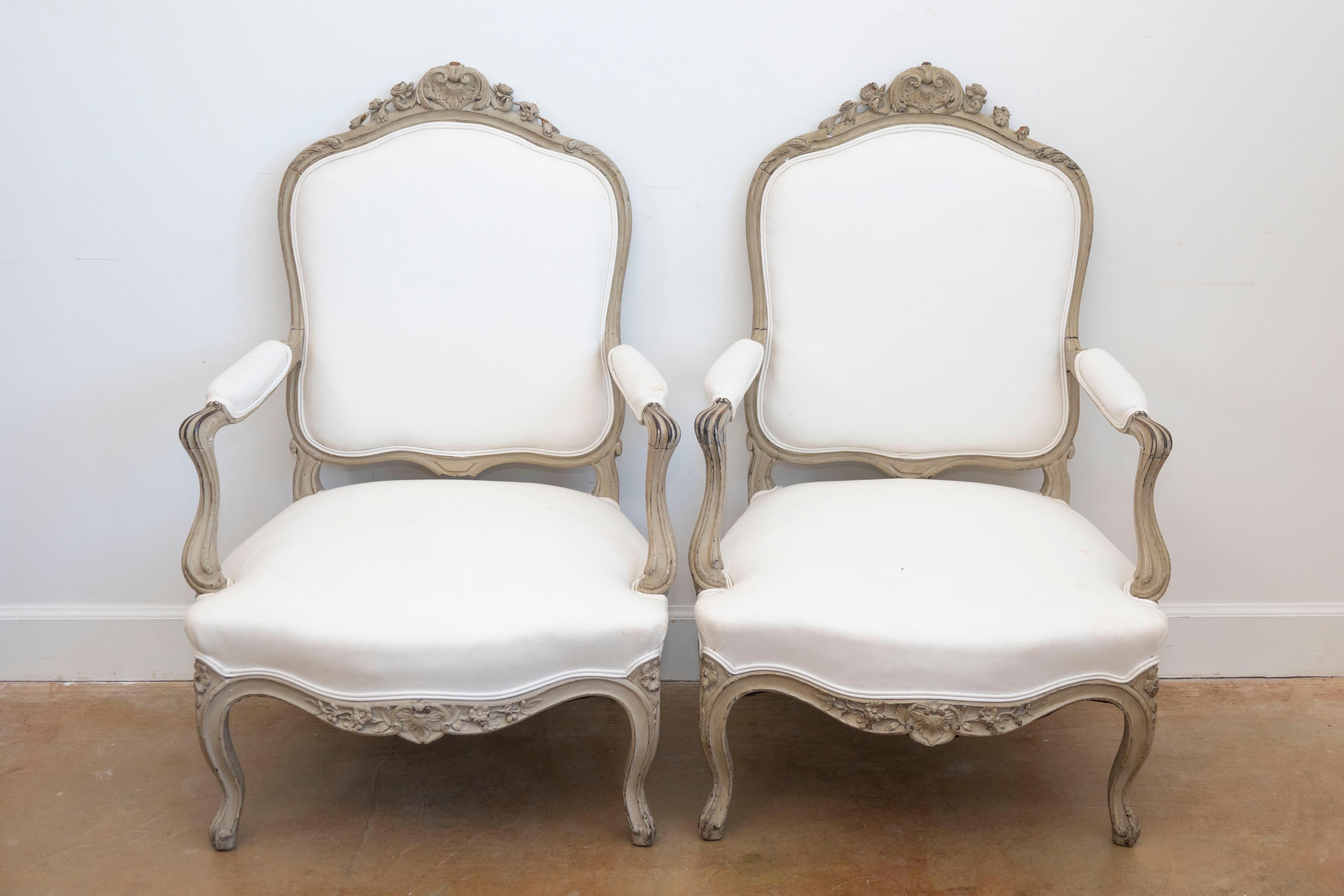 Paire de fauteuils en bois peint d'époque Napoléon III, datant du milieu du XIXe siècle, avec un décor floral et feuillu sculpté. Créée en France au début du règne de l'empereur Napoléon III, cette paire de fauteuils présente un dossier légèrement