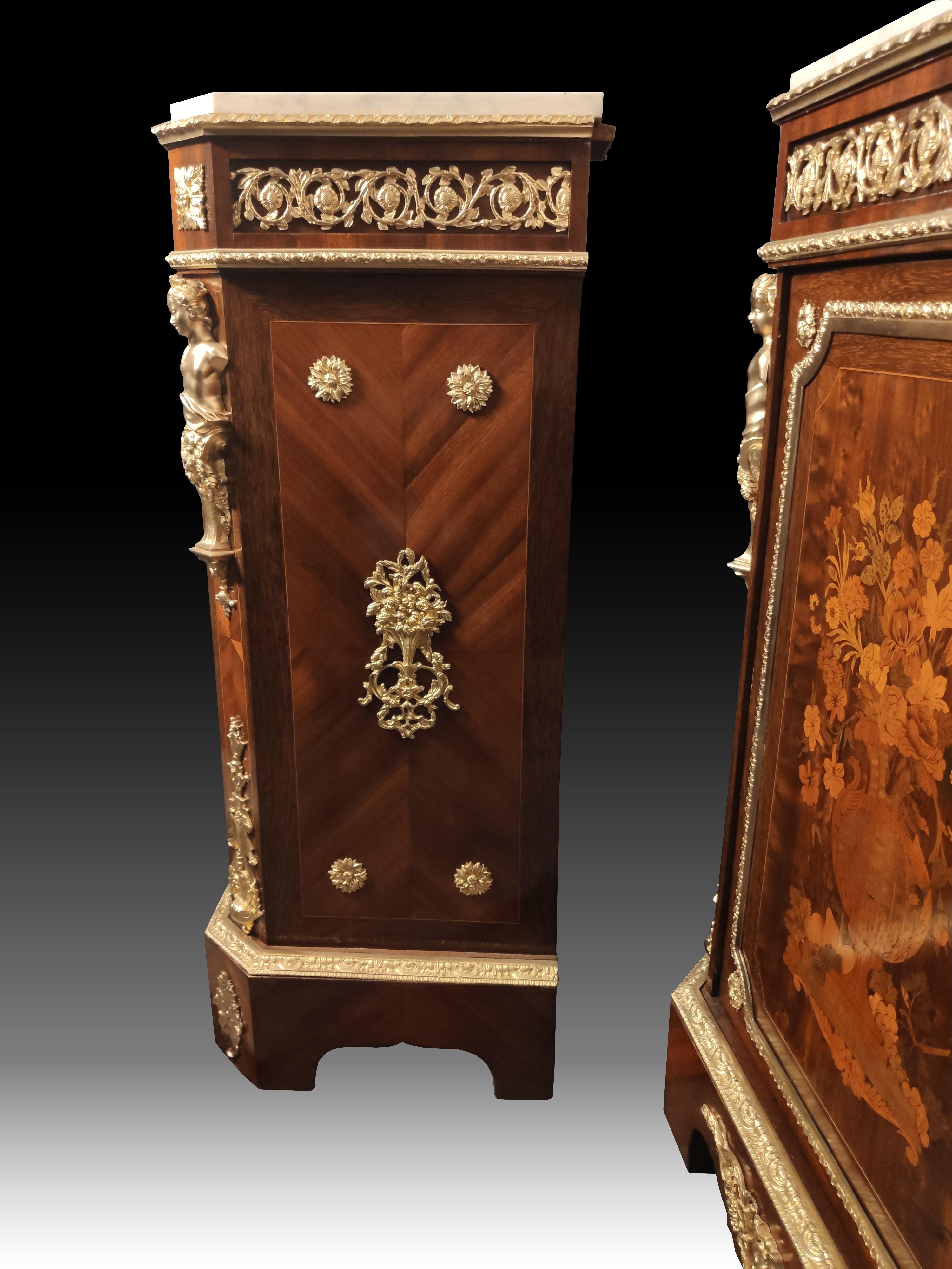 Pair of cabinets with rich decoration in wood marquetry tinted with flowery vases on a background of rosewood, mahogany and rosewood.
 Amounts with cut sides, rich ornamentation of gilded and chiseled bronzes in caryatids, oves, shells. 
White