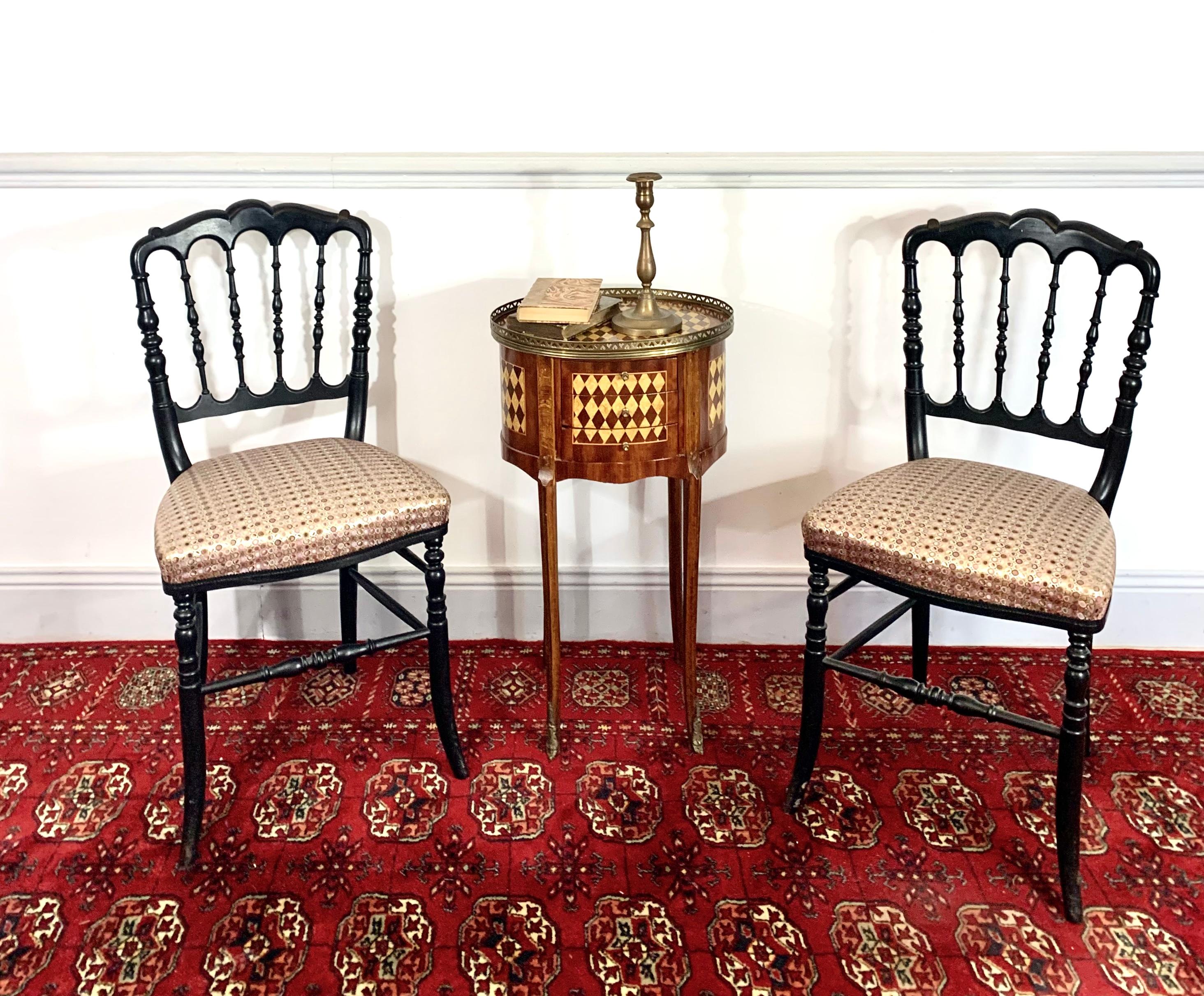 Nice pair of Napoleon III style chairs. The structure of this chair is made of blackened wood. The uprights are made of turned wood. The seat is covered with a jacquard fabric in violet colors.