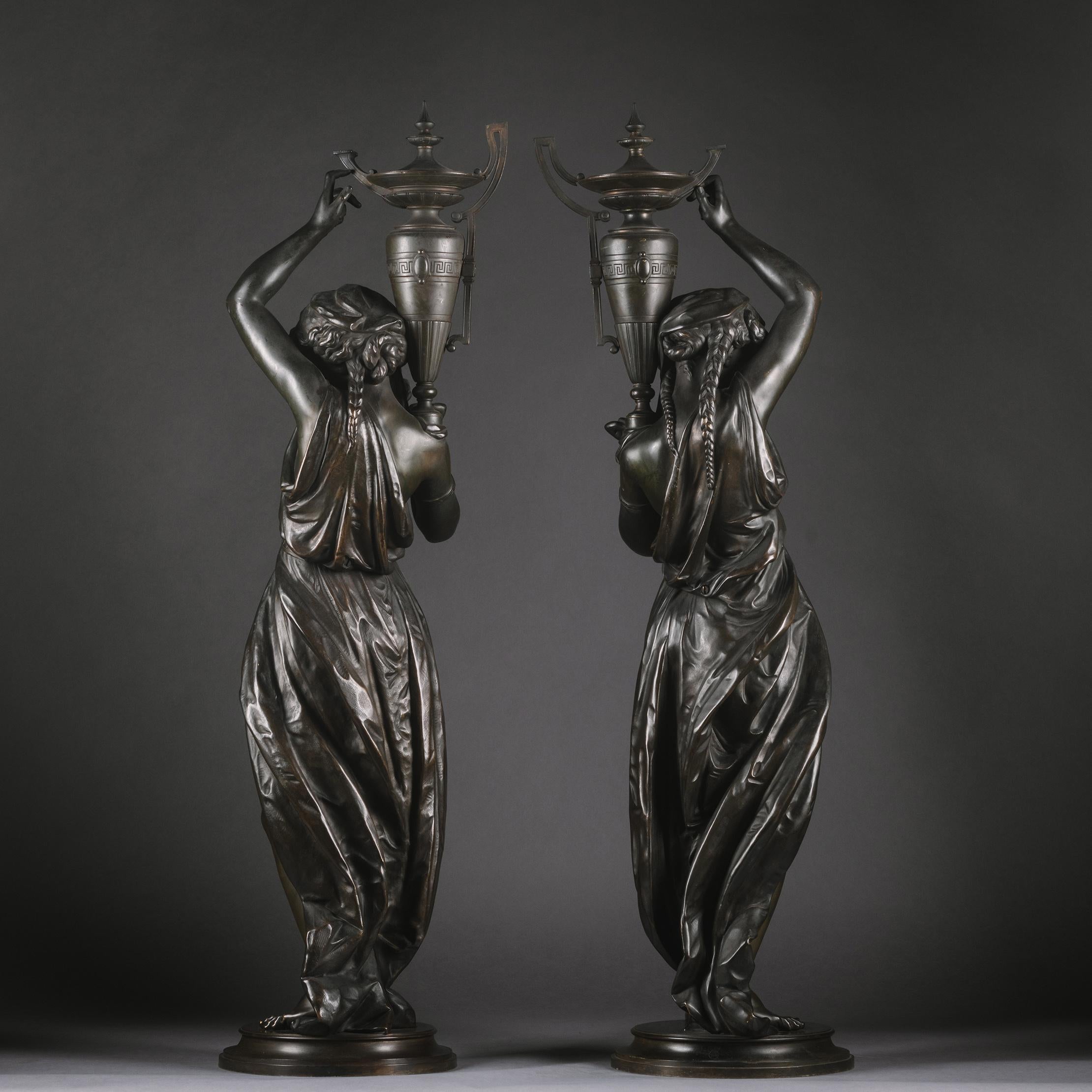 Victor Paillard (French, 1805-1886)
A Pair Of Napoleon III Patinated-Bronze Figures, Modelled As Classically Robed Maidens Bearing Urns.

The models attributed to Albert-Ernest Carrier-Belleuse (French, 1824-1887).

Each with oval stamp  'VOR