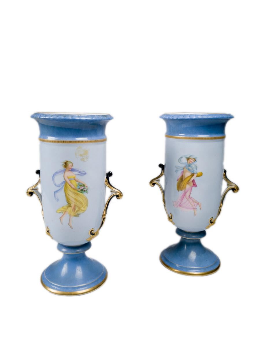 A pair of 19th century French porcelain vases features a striking royal cobalt blue glaze and a hand-painted yellow dress motif. 

Attributed to the Nast manufactory.

A must-have for collectors of antique porcelain.

Take into account that the