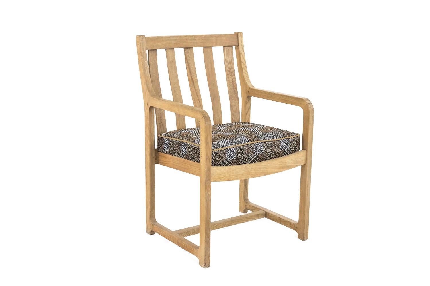Paar Sessel aus Natureiche mit durchbrochener Rückenlehne aus fünf vertikalen Stäben, leicht gewölbt. Sie stehen auf Schlittenbeinen.

Die Garnitur besteht aus einem quadratischen Kissen.

Arbeiten aus den 1950er-1960er Jahren.