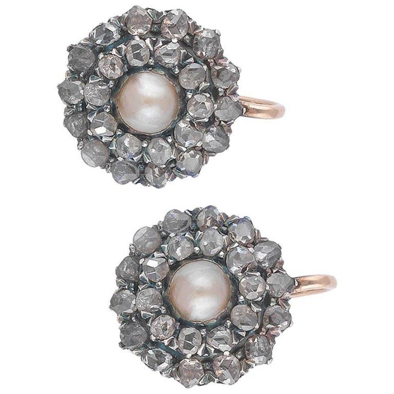 
Each 5.5mm or 5.9mm natural button pearl, within a rose-cut diamond oval surround, length 2.1cm