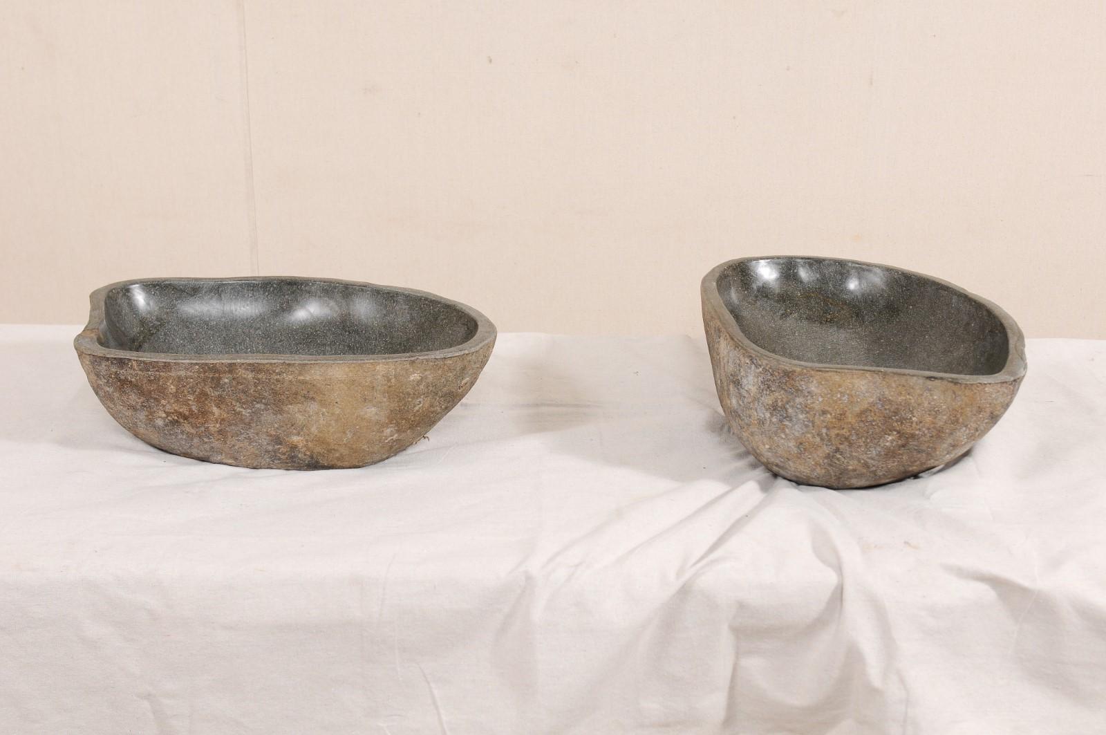 A pair of river rock wash basins. This pair of sinks have each been carved from a single, natural river rock boulder. Each sink has a polished bowl with natural stone on the exterior. Beautifully organic designs courtesy of Mother Nature, no two