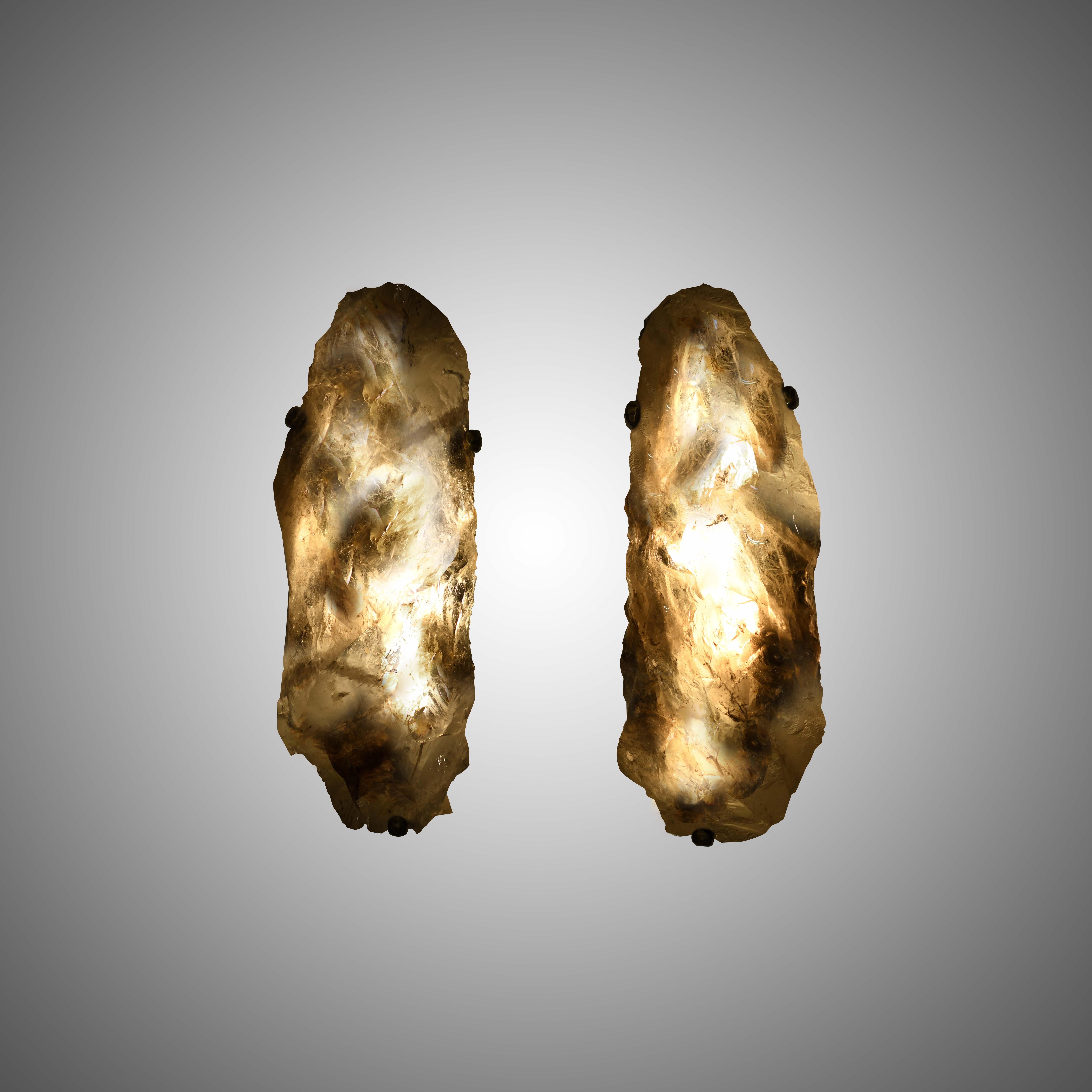 Pair of natural smoky rock crystal quartz wall sconces with antique brass-mounted, selected from natural rock crystal with the beautiful natural surface. The shape of the sconces is the only pair in the world. Created by Phoenix gallery. 
Custom