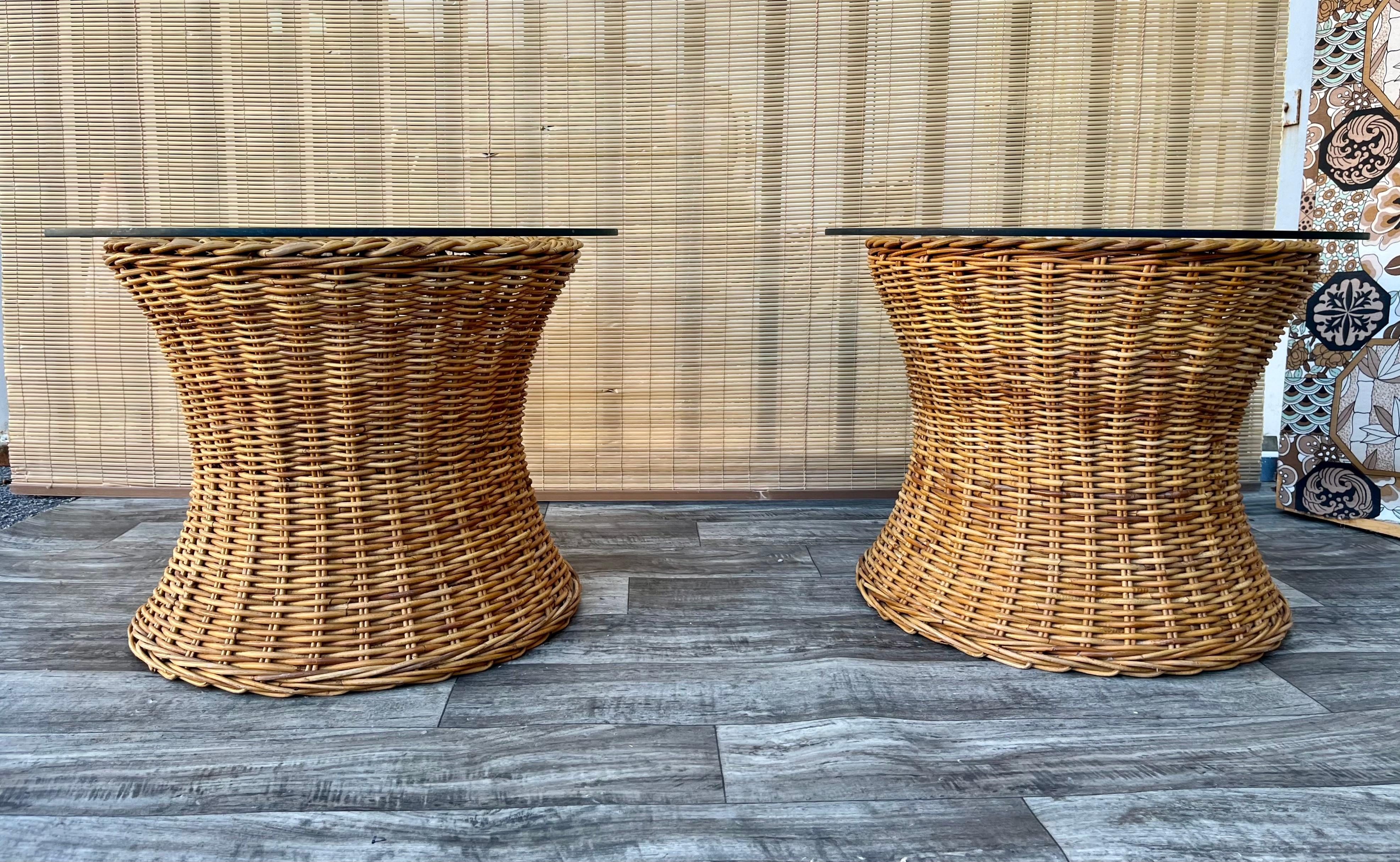 A Pair of Vintage Large Scale, Natural Wicker/Rattan Coastal Style Round Side Tables in the Bielecky Brothers' manner. Circa 1970s
Features a beautiful glowing honey colored weaved rattan frame with an elegant braided trim detail at top edges, and