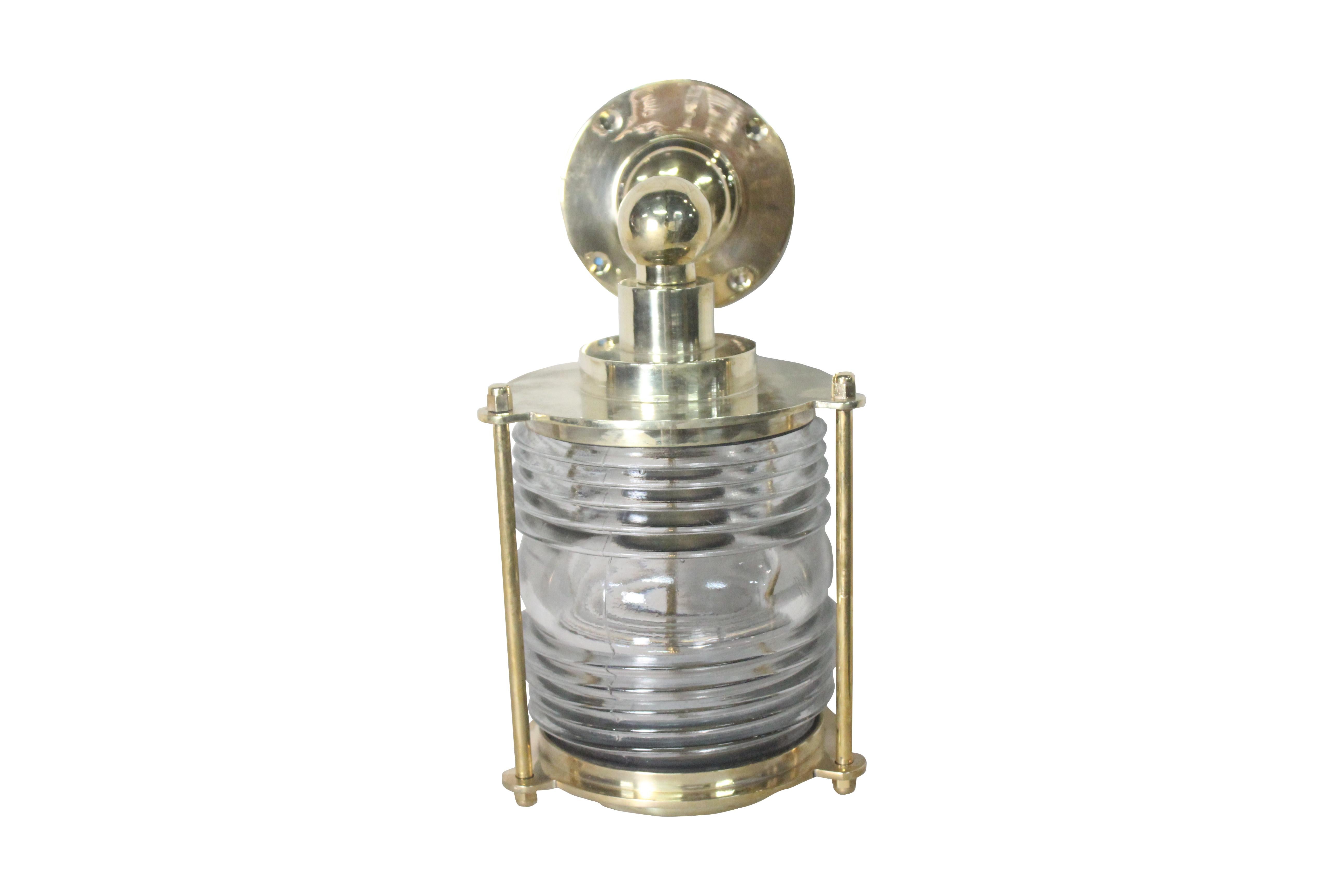 A fabulous and robust pair of brass ship's post lights with Fresnel glass lens converted to wall-mounted sconce lights which can be used indoors or out. Originally European, these have been rewired for American use. Takes a standard base bulb.