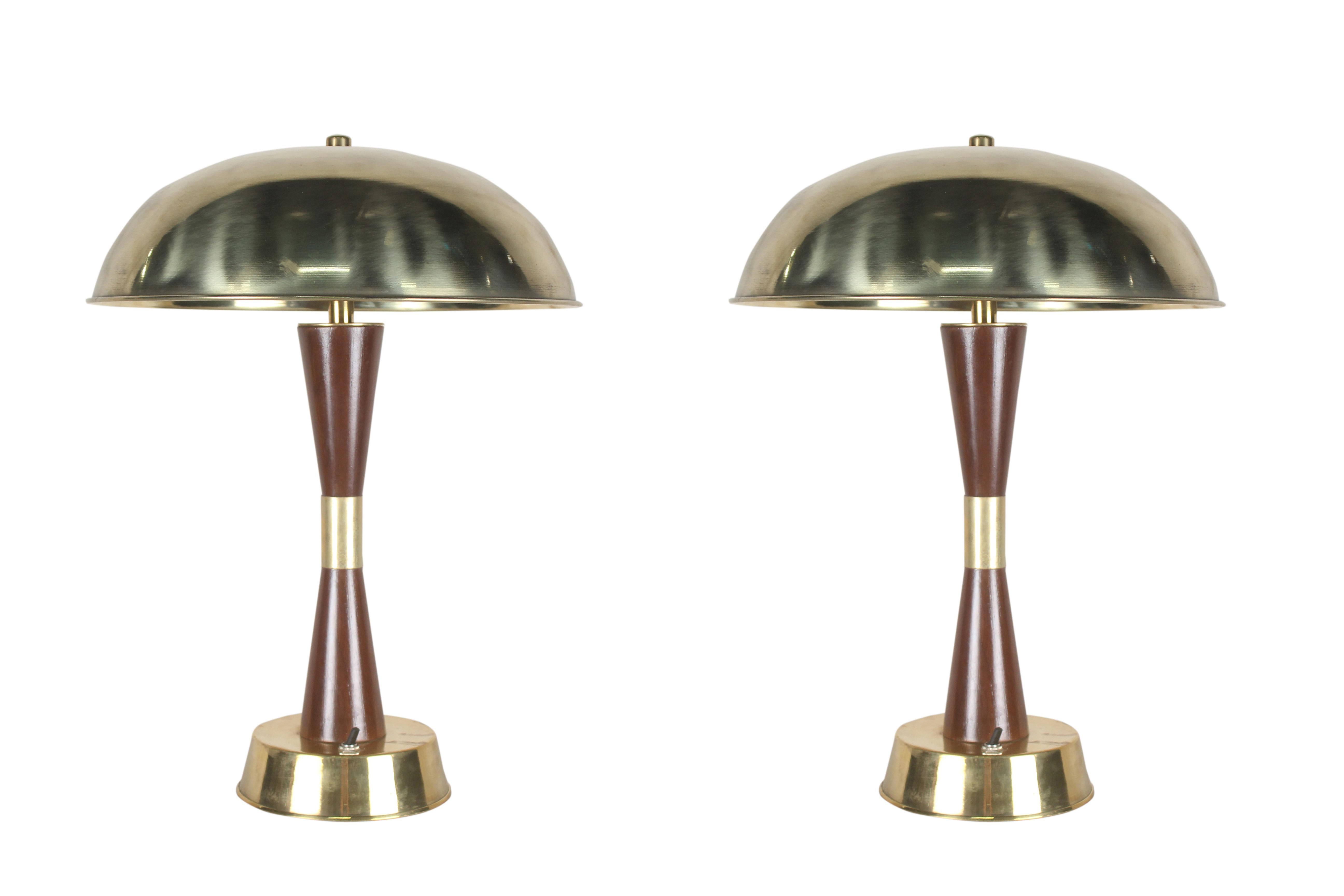 A handsome pair of teak and brass table lamps from the stateroom of a decommissioned cruise ship. 1980's. On/off switch at base. Rewired for American use. Base diameter is 6