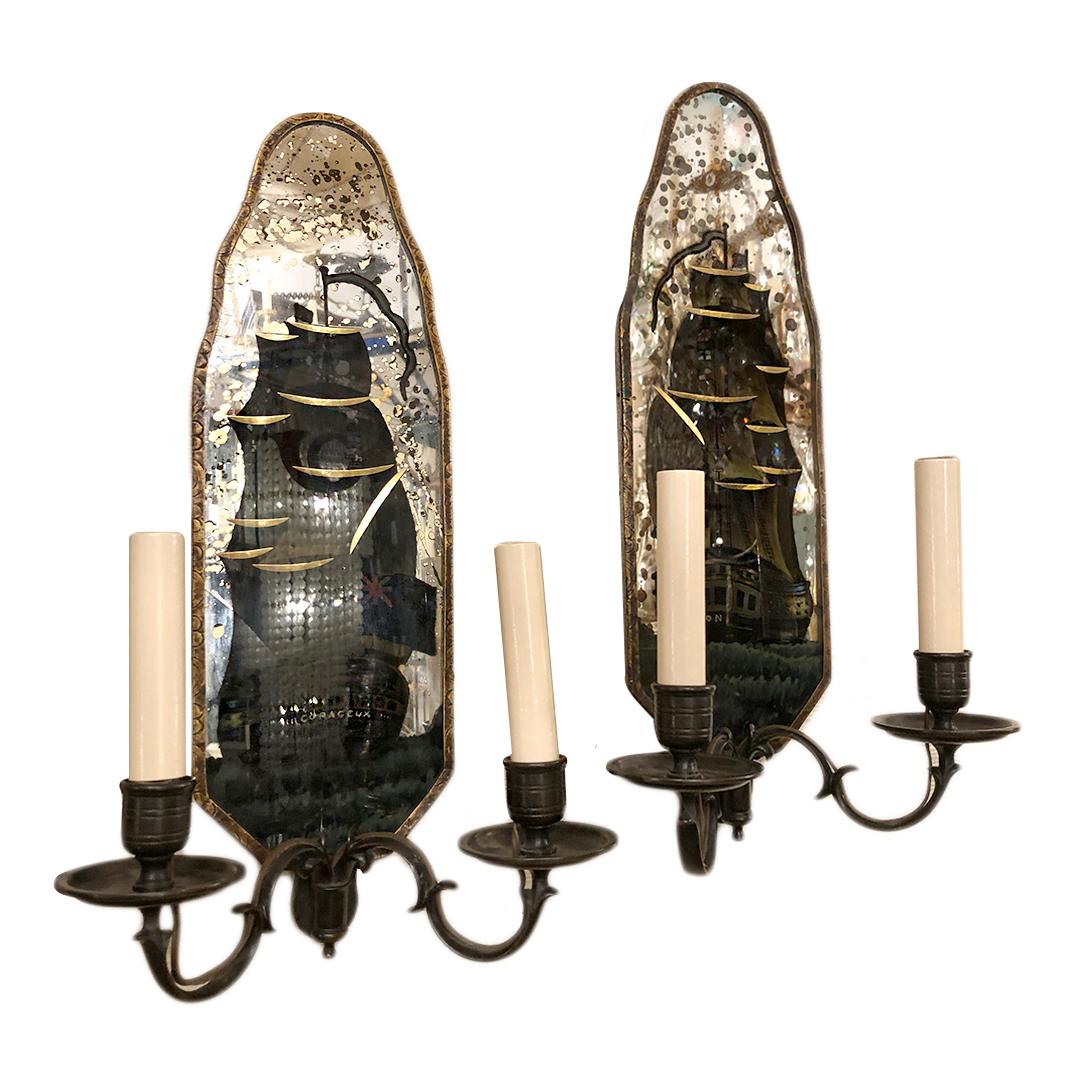 A pair of circa 1920’s American  mirrored sconces with etched and reverse painted ships. One of the sconces has a crack, see detail image.
Measurements:
Height: 17.75″
Width: 9.5″ (widest point from arm to arm)
Depth: 5.25″
  