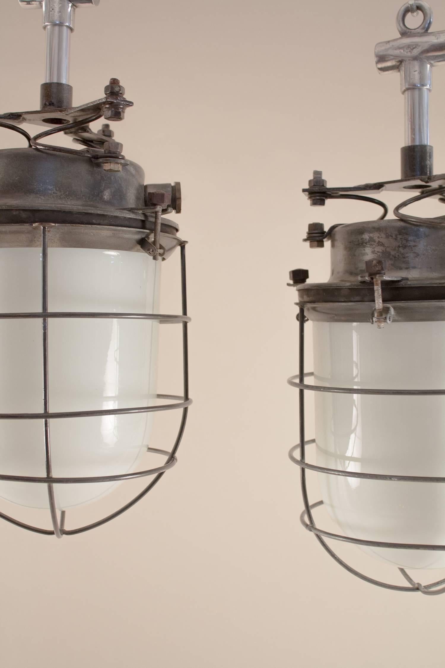 Paar nautische oder industrielle Pendelleuchten aus Milchglas und Stahl mit Käfig (Industriell)