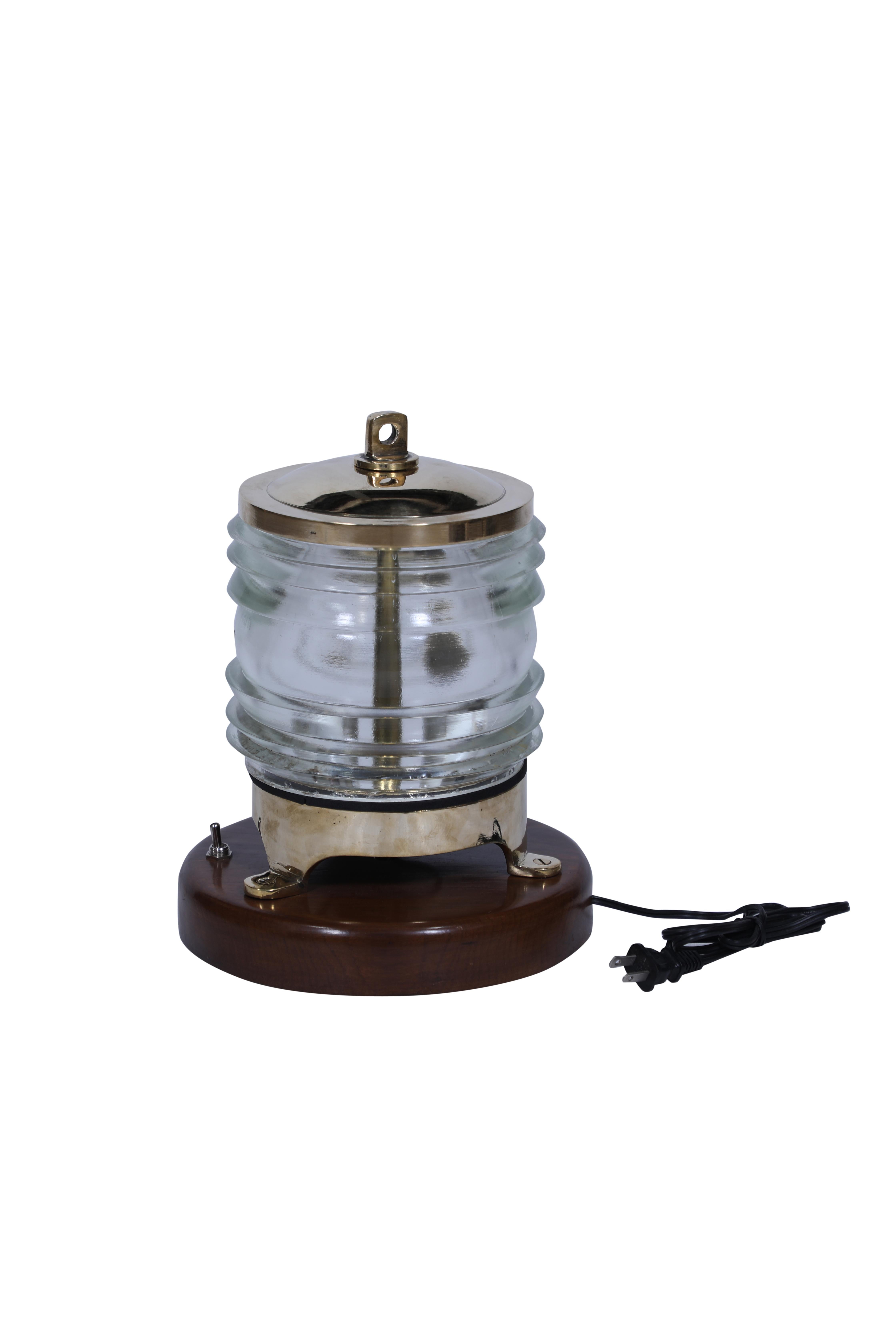 Un par de luces de poste de latón de un barco desguazado con lente de Fresnel.  Montada sobre una base de teca de 9