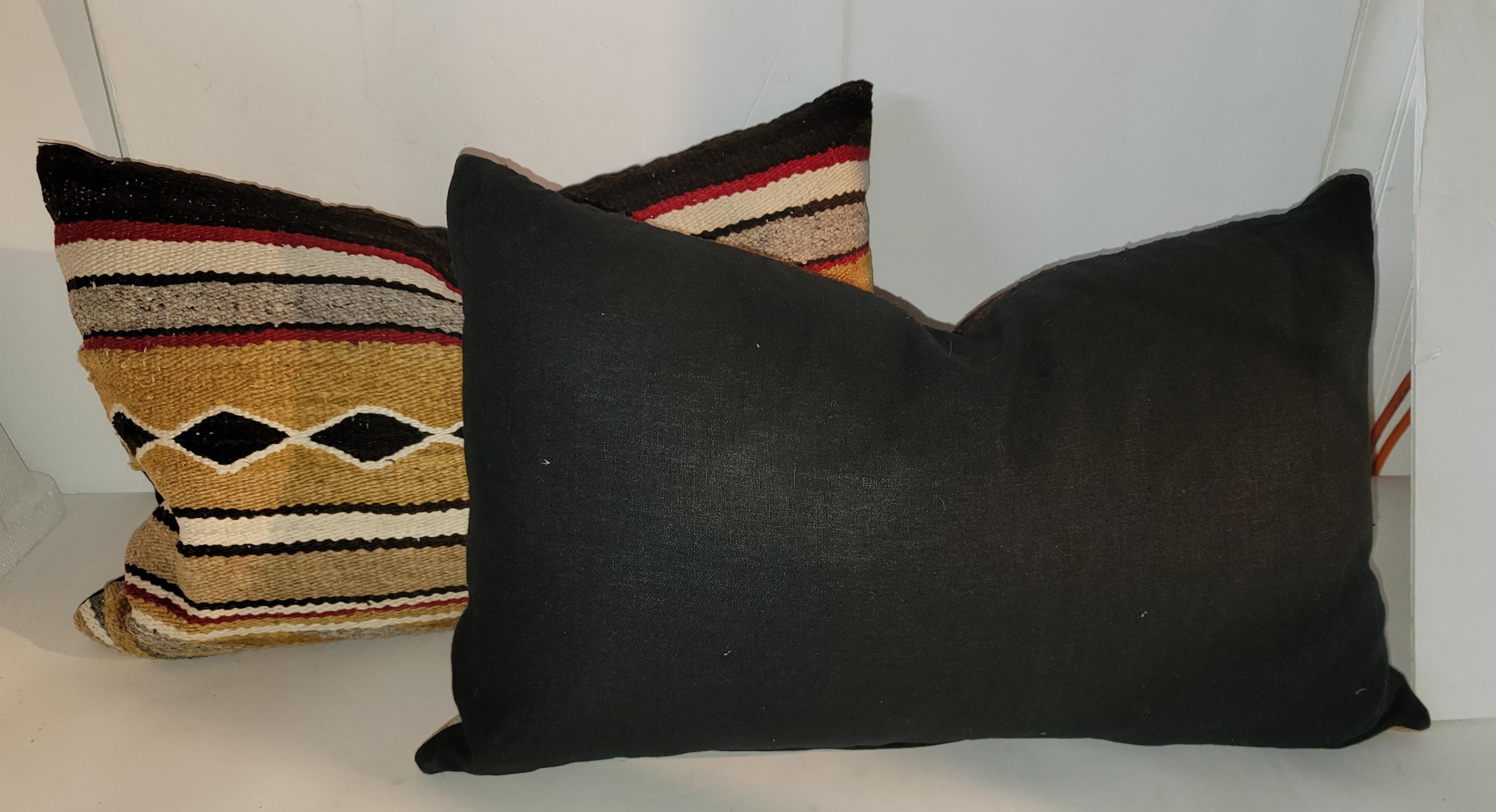 Pair of Navajo Chinle wool rug custom made pillows. Black linen backing and zipper casing. Feather and down insert.