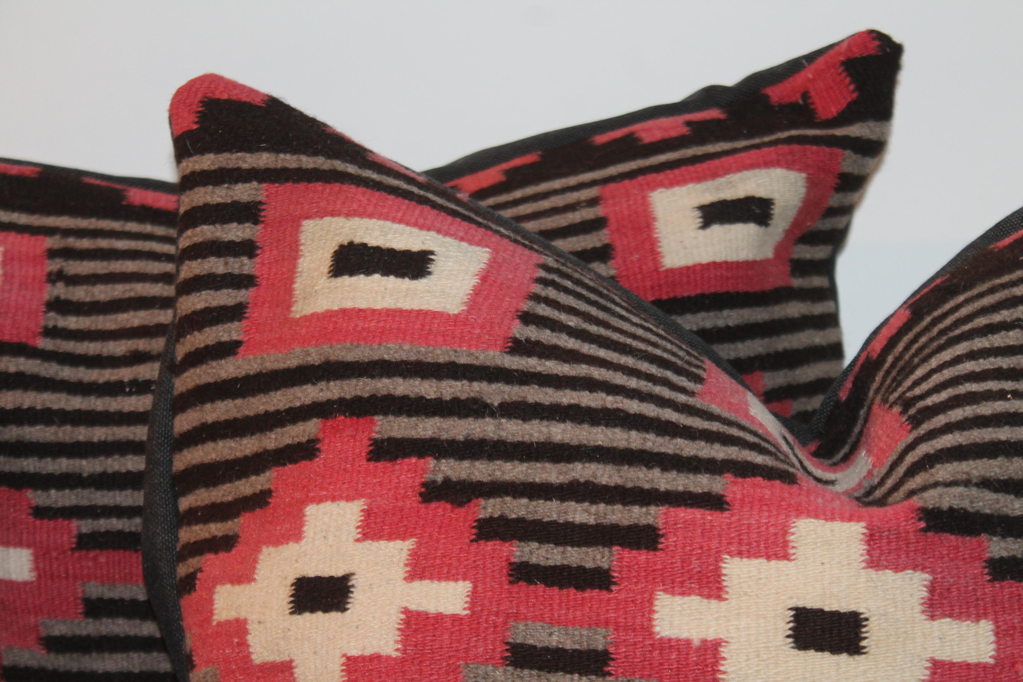 These folky eye dazzle Navajo Indian weaving bolster pillows are in fine condition. The backings are in black linen fabric.