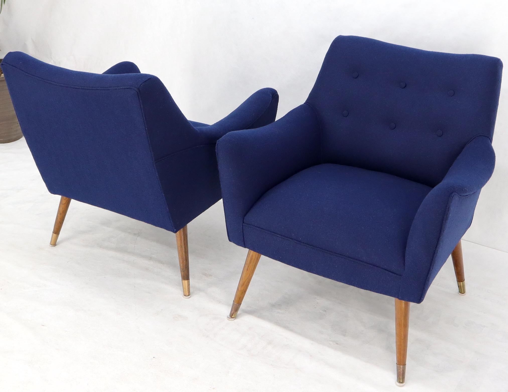 Pair of Mid-Century Modern new navy blue upholstery lounge chairs on tapered dowel legs.