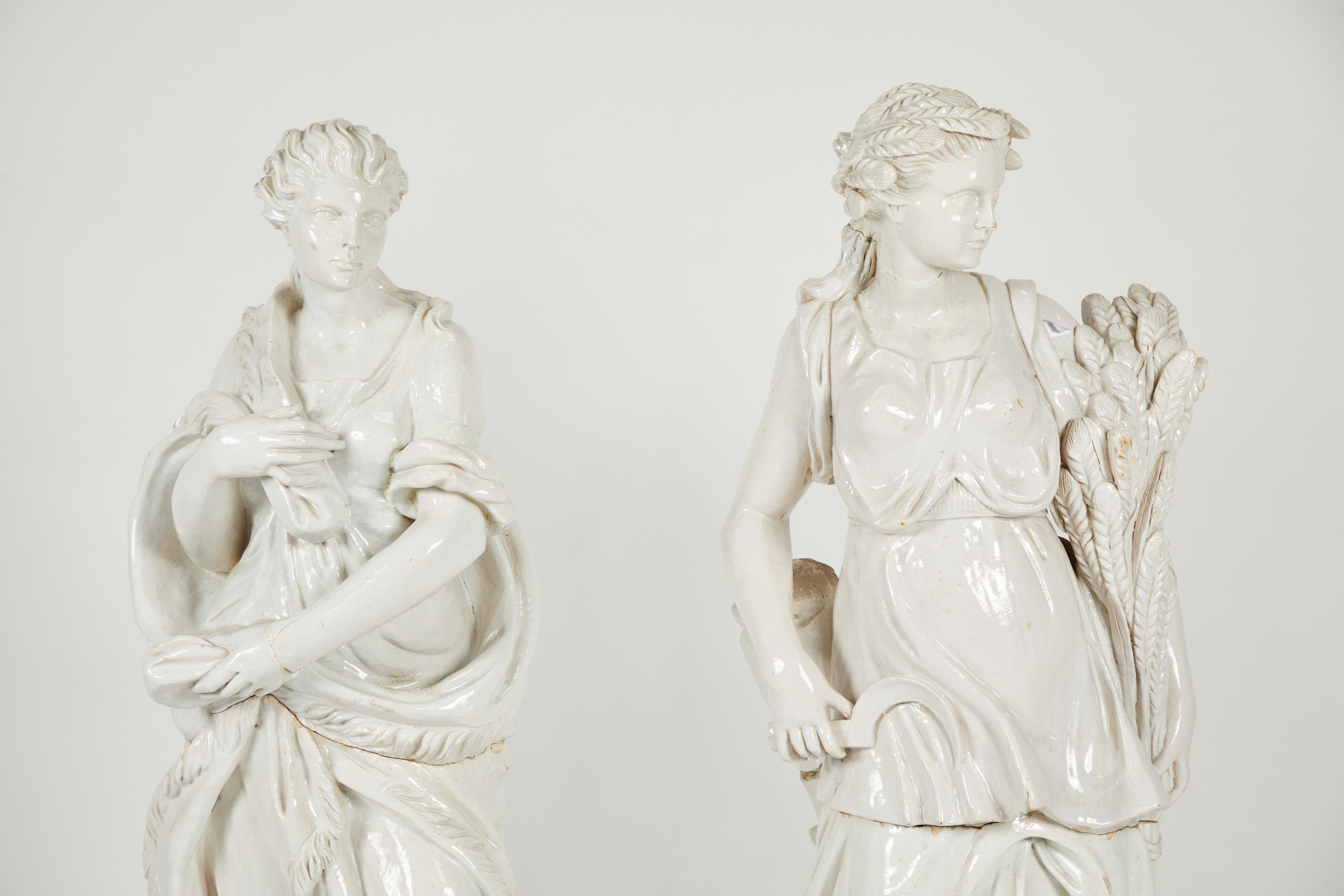 A pair of near life-size continental glazed earthenware figures emblematic of two of the seasons.
Post 1950.