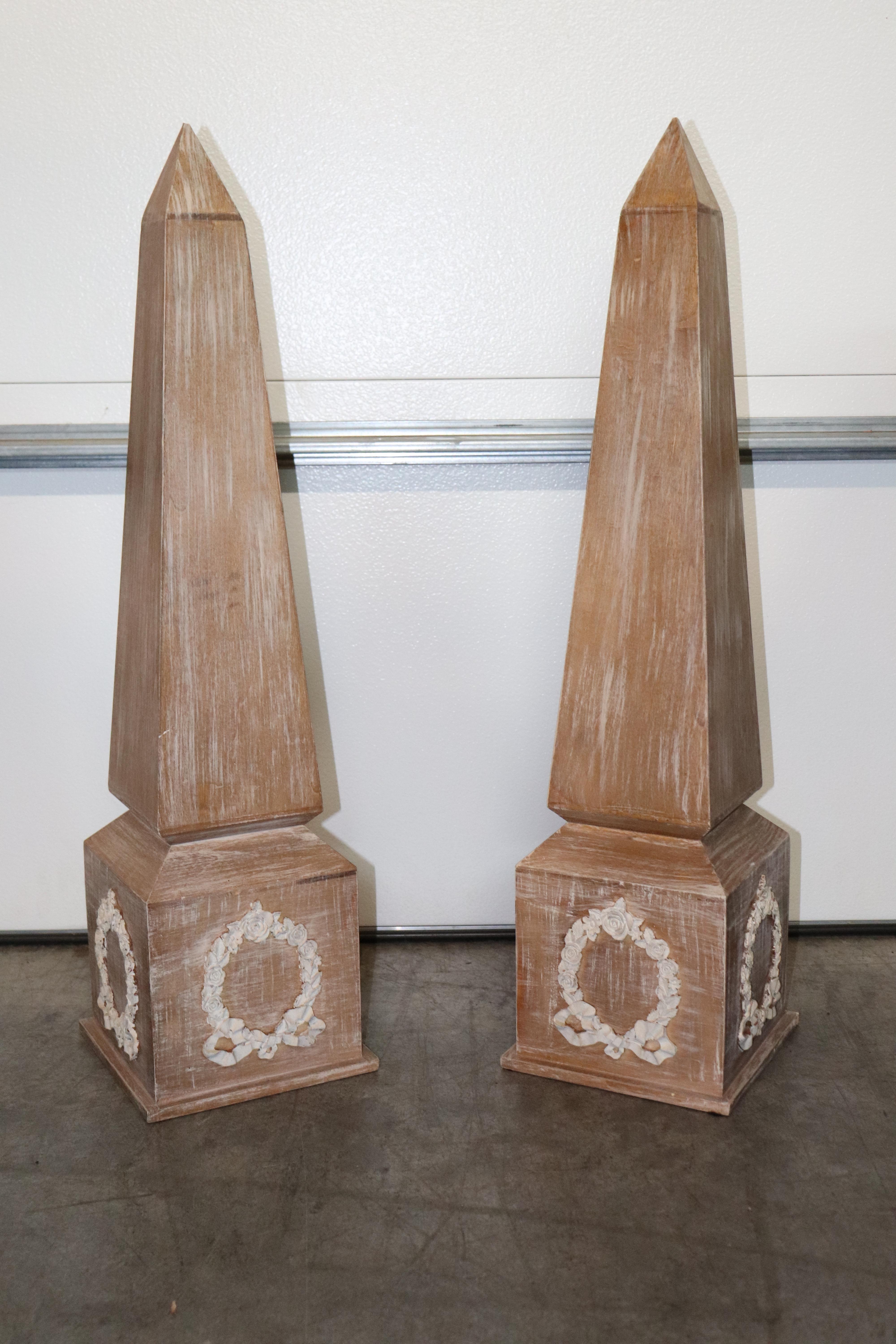 This is a wonderful pair of Egyptian revival obelisks done in the French empire style with carved wreathes on each side of the base. The obelisks are made of oak and cerused for a more sophisticated finish. They measure 33.75 inches tall x 8.75
