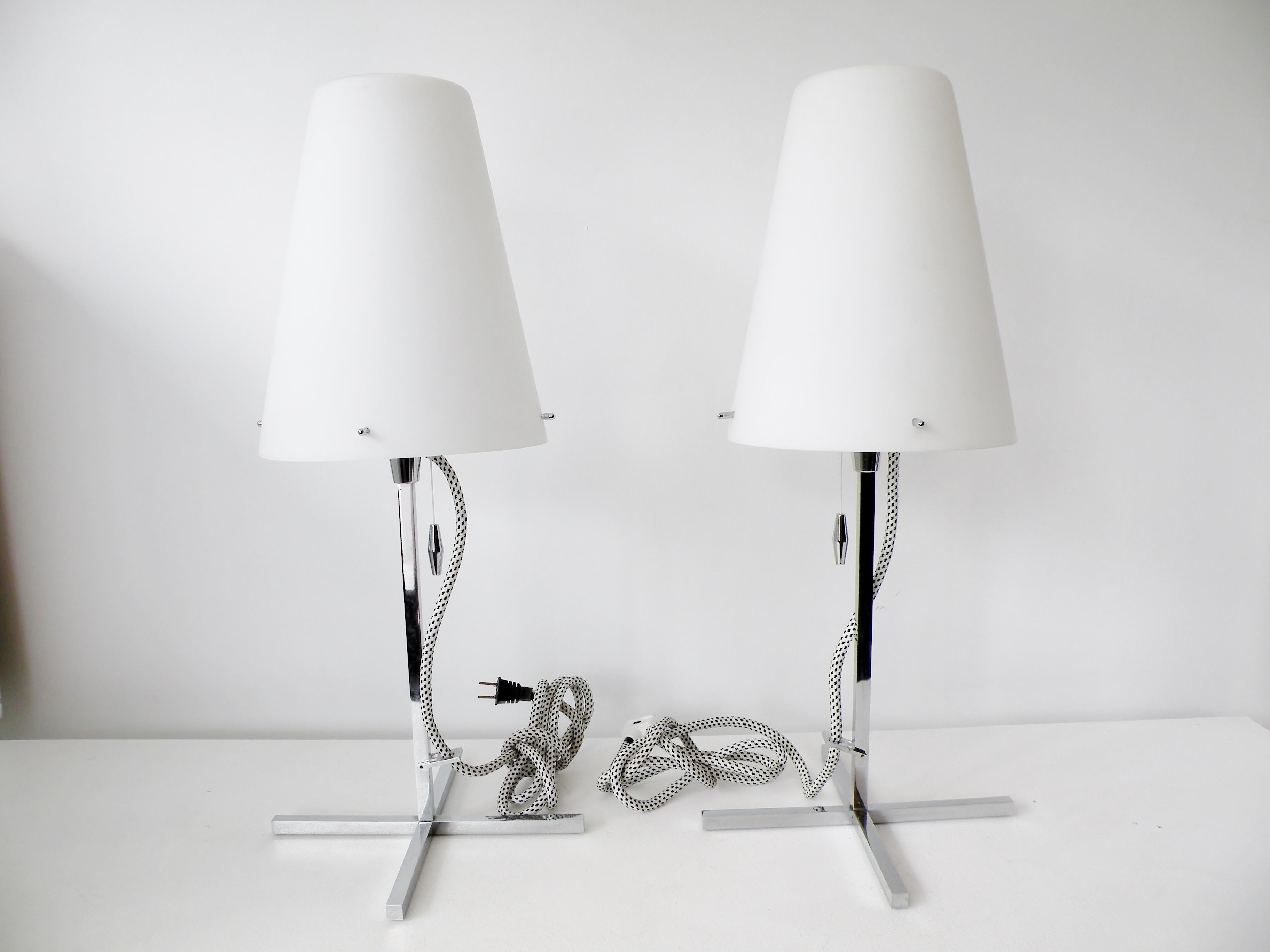 Pair of Nemo Thuban Tavolo table lamps designed by Hannes Wettstein. Bodies of polished chrome steel with clean Italian modernist lines, satin white blown glass diffuser shades, and white/ black fabric covered cords with in line dimmers.