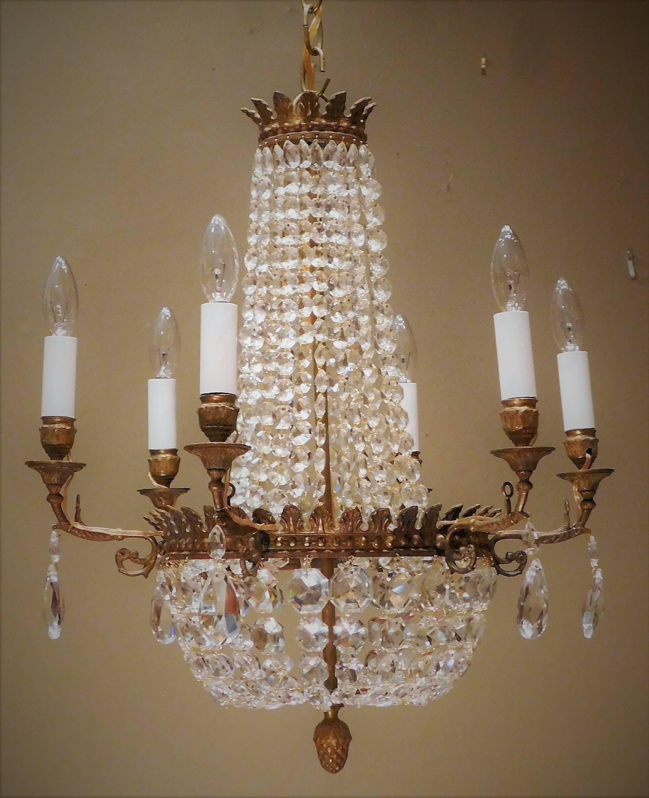 Pair of hand cast gilt bronze Empire style chandeliers with French lead crystal prisms. Ceiling cap, hanging hardware and 1 foot of chain included in the price.