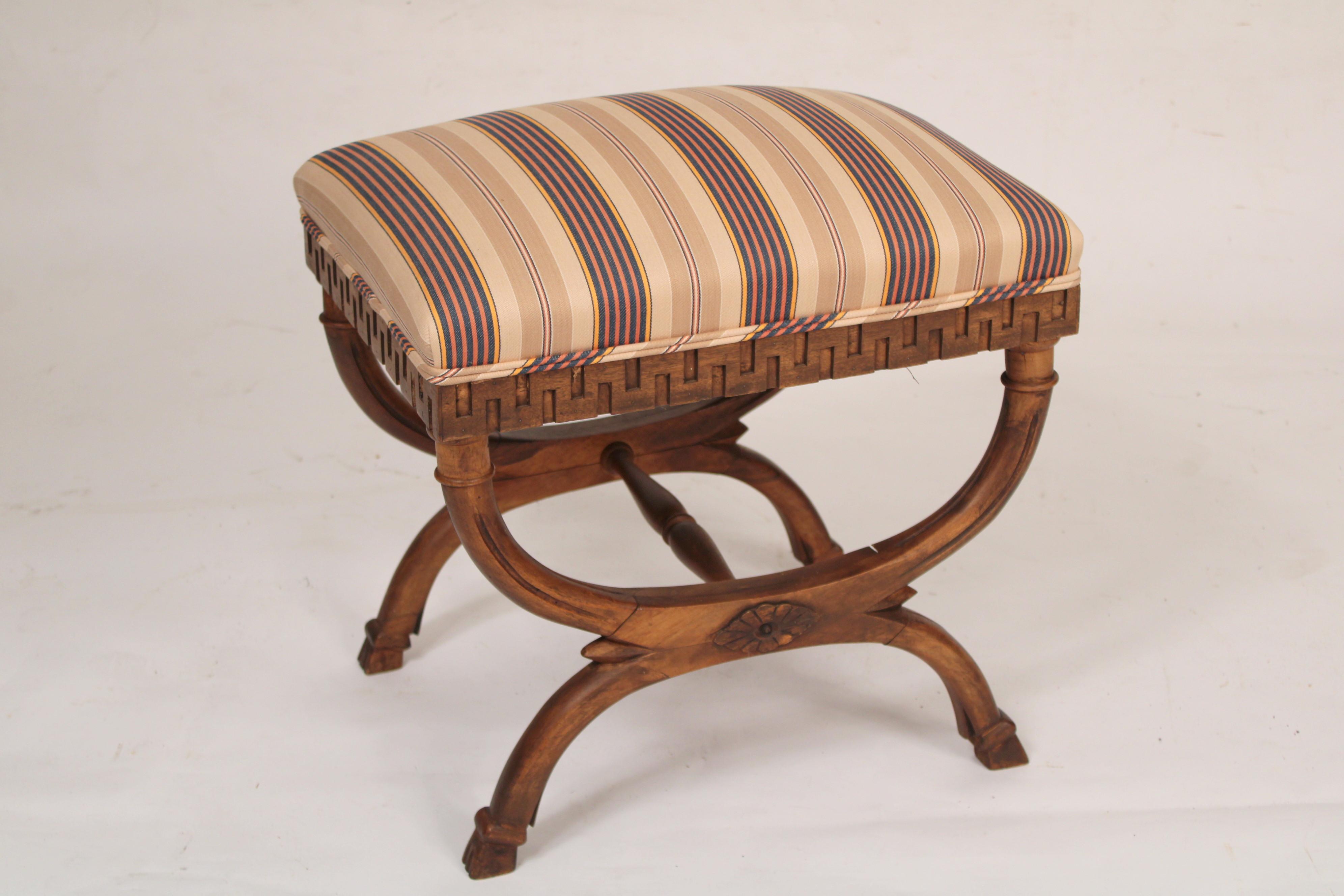 Pair of neo classical style curule form beech and walnut benches, mid-20th century. With 
Greek key aprons and curule form legs ending in cloven feet.