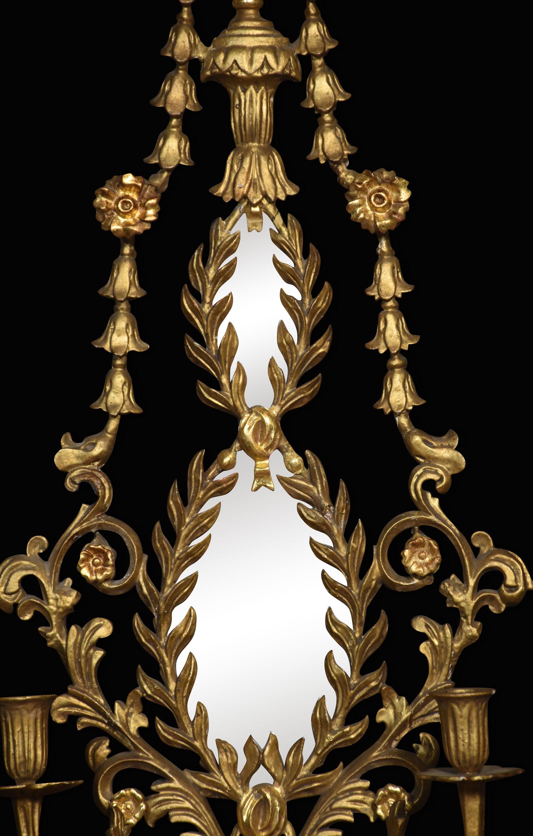 Pair of Neo-Classical style giltwood girandoles, each with vase surmount over twin oval mirrors within laurel wreath frames flanked by bellflower swags, fitted twin branch candle sconces.
Dimensions
Height 40.5 Inches
Width 15.5 Inches
Depth 5.5