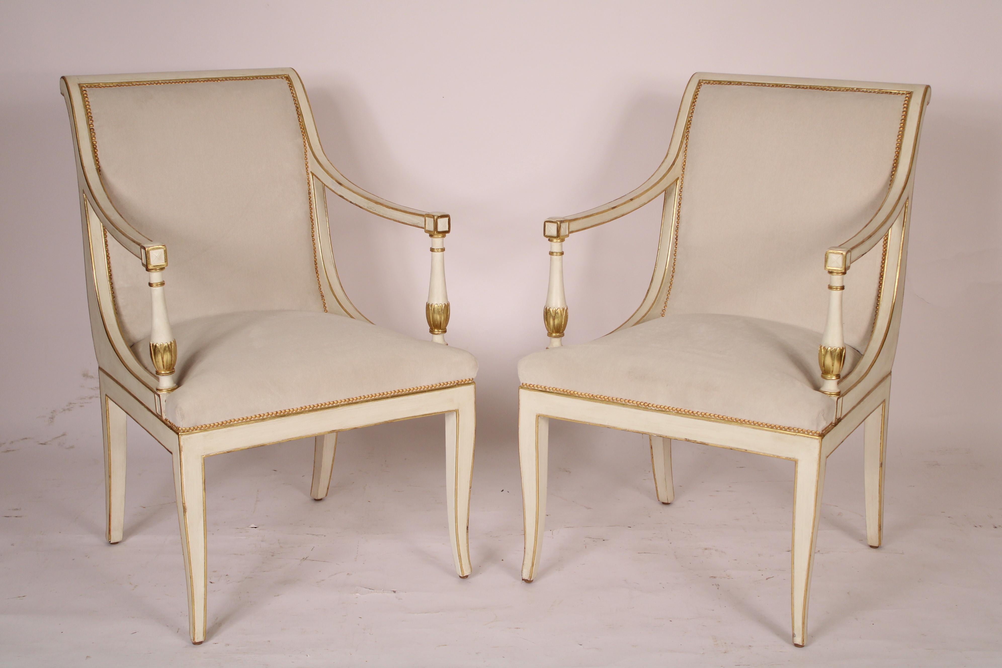 Pair of Northern European neo classical style painted and gilt decorated armchairs, circa 1970's. With scroll shaped crest rail, serpentine shaped back  as seen from sides upholstered with gold nail head trim,  down swept arms supported with