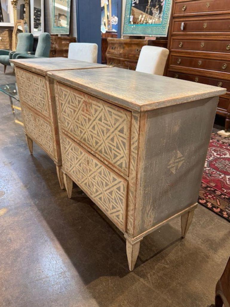 Este par de mesas auxiliares pintadas de estilo neoclásico presenta un motivo geométrico que añade un toque moderno y elegante a cualquier habitación. Su diseño elegante y su patrón único hacen de estas mesas un complemento versátil y llamativo para