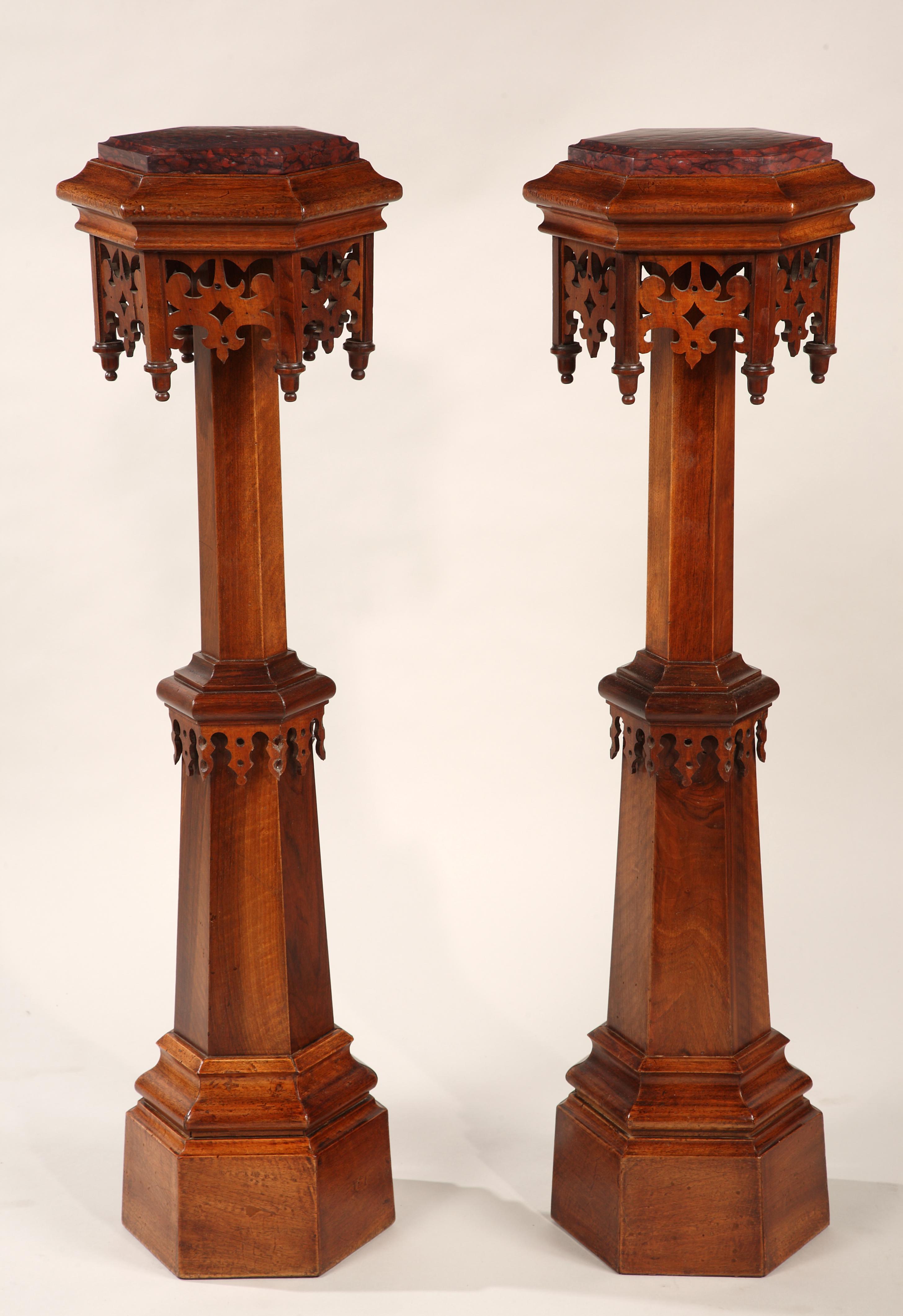 A very fine pair of Gothic Revival natural wood stands. Each composed of a hexagonal molded red Griotte marble top, resting on a hexagonal tapering shaft. Adorned all-over with carved and pierced walnut pinnacles and lambrequins.

The somewhat
