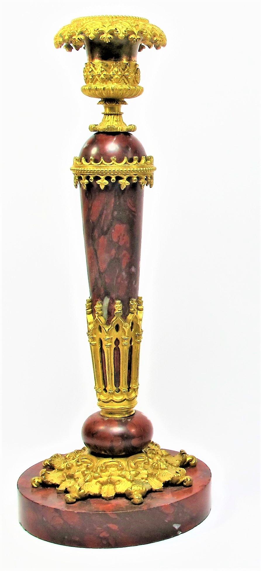 Beautiful pair of candlesticks from 1830 period in gilt bronze and cherry red marble neo-gothic style. The bronze decorations representing architectural elements have been used in the service of red cherry marble in order to sublimate the aesthetic
