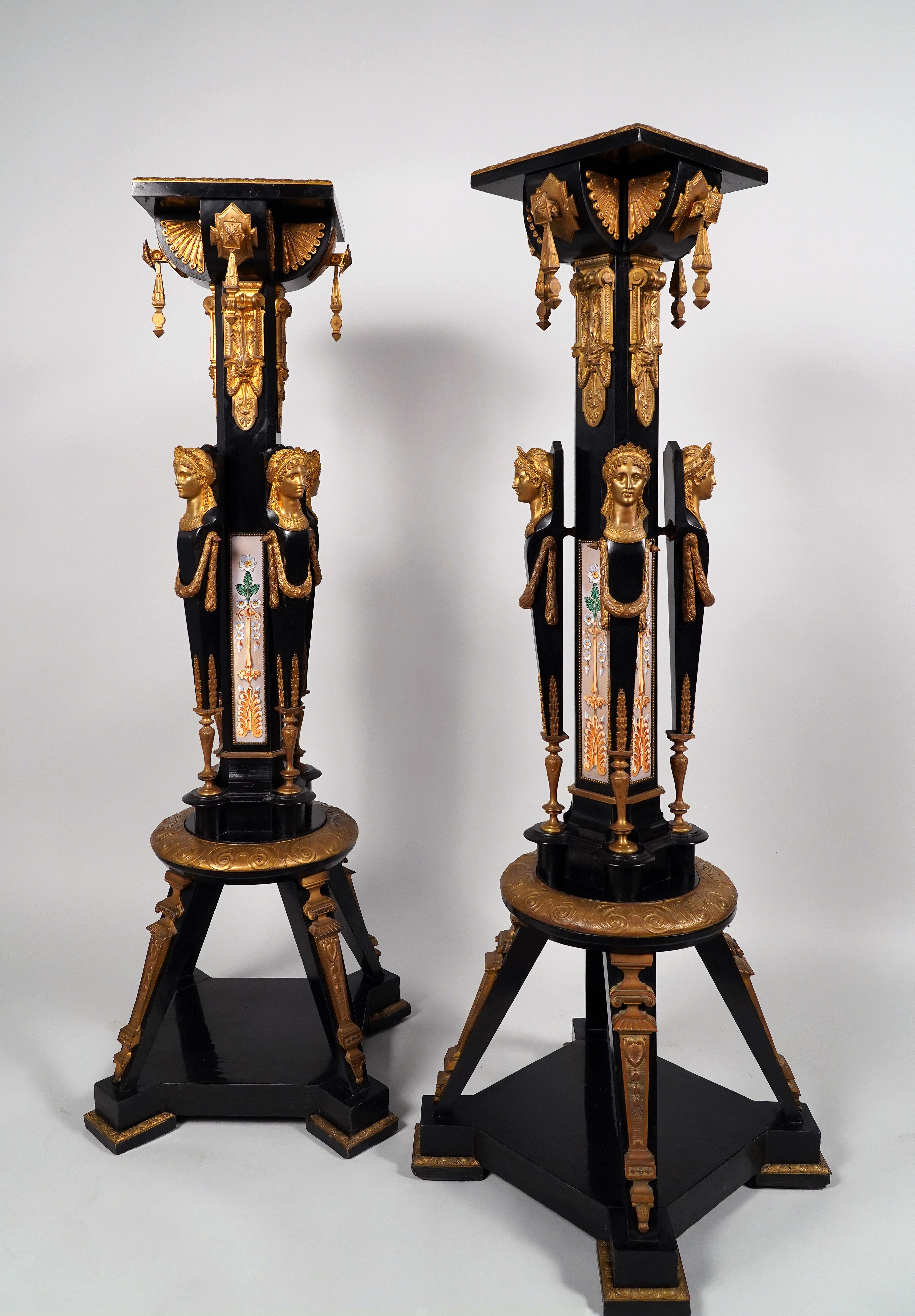 Exceptional pair of neo-Greek style pedestals, made in blackened pearwood, gilded galvanic bronze and glazed earthenware. The sheath-shaped shaft is decorated with rectangular plates in glazed earthenware with floral decoration and palmettes framed