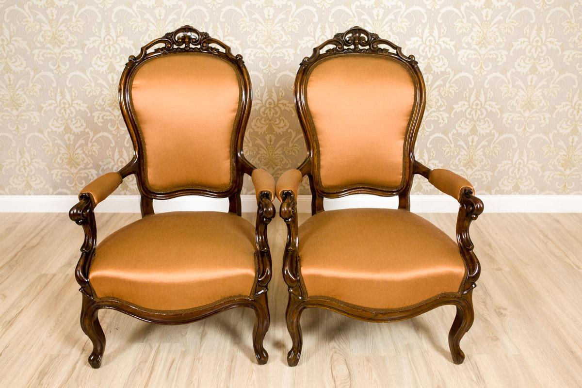 The frames of the armchairs are made in mahogany wood. The seats, backrests and the armrests have been upholstered.
The front legs are cabriole-bent. The armrests are finished with volutes.
Furthermore, the crests of backrests are ornamented with
